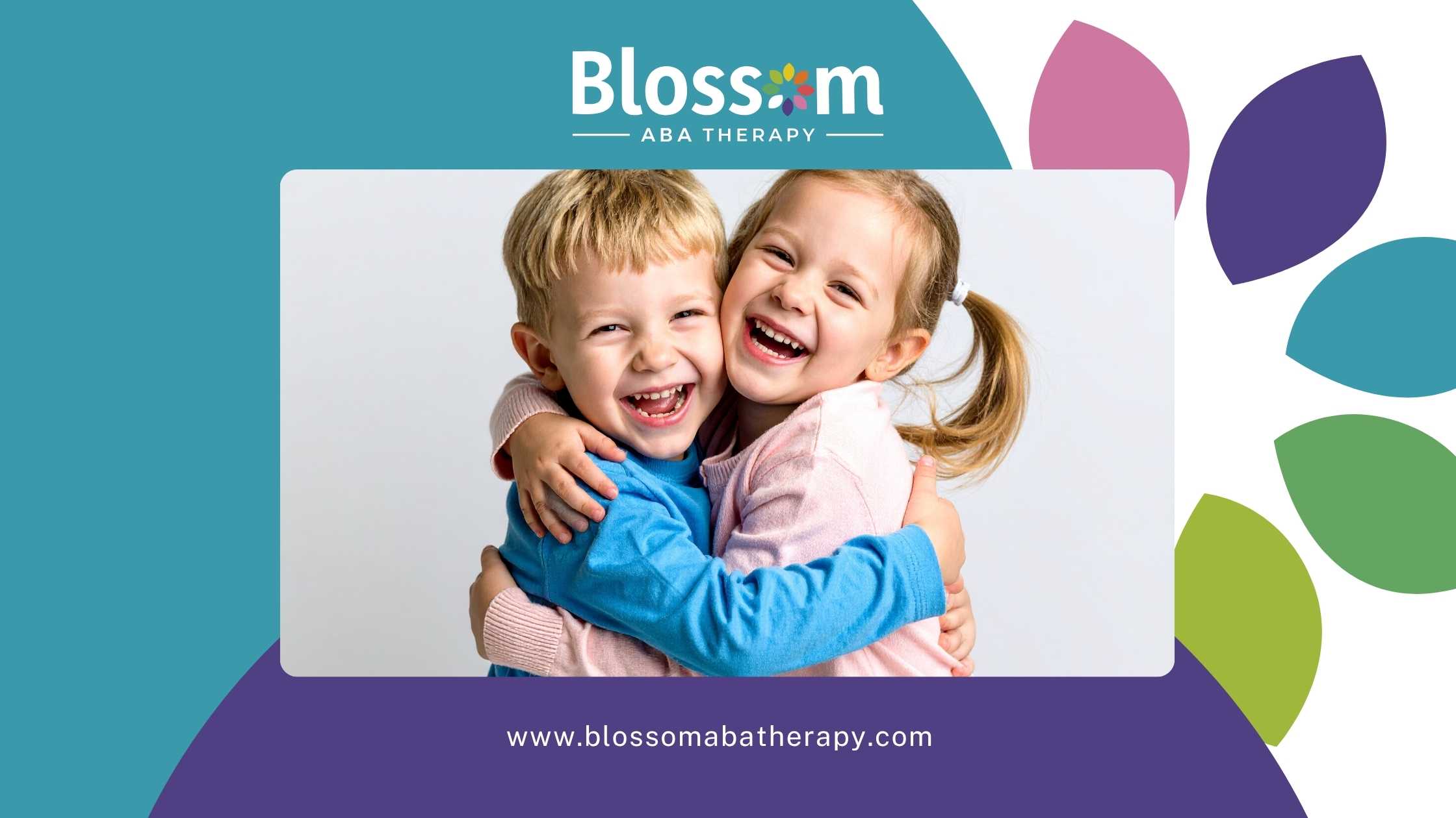 Two young children, a boy in a blue sweater and a girl in pink, hug and smile joyfully. 