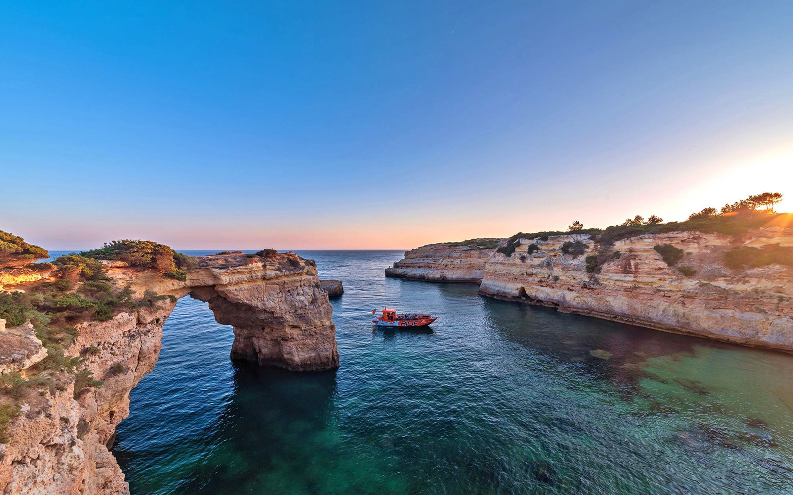 Exploração de cavernas costeiras de barco durante o X Ride Tour de Golfinhos e Cavernas ao pôr do sol.