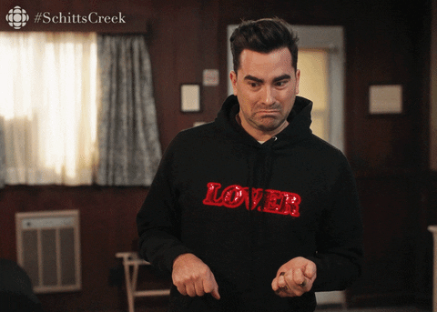 David Rose from Schitt's Creek gestures with open hands, looking confused, captioned #SchittsCreek.