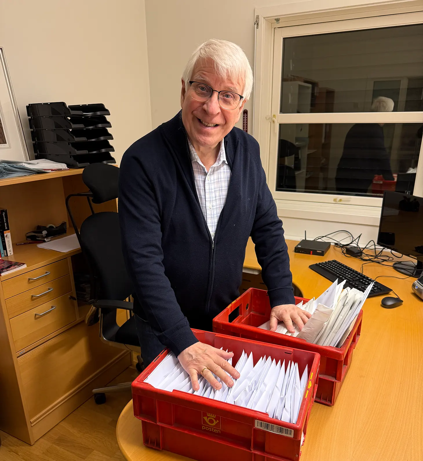 Bilde av Svein-Magne Pedersen som legger sine hender på dagens post med olje og plakater som skal sendes ut.