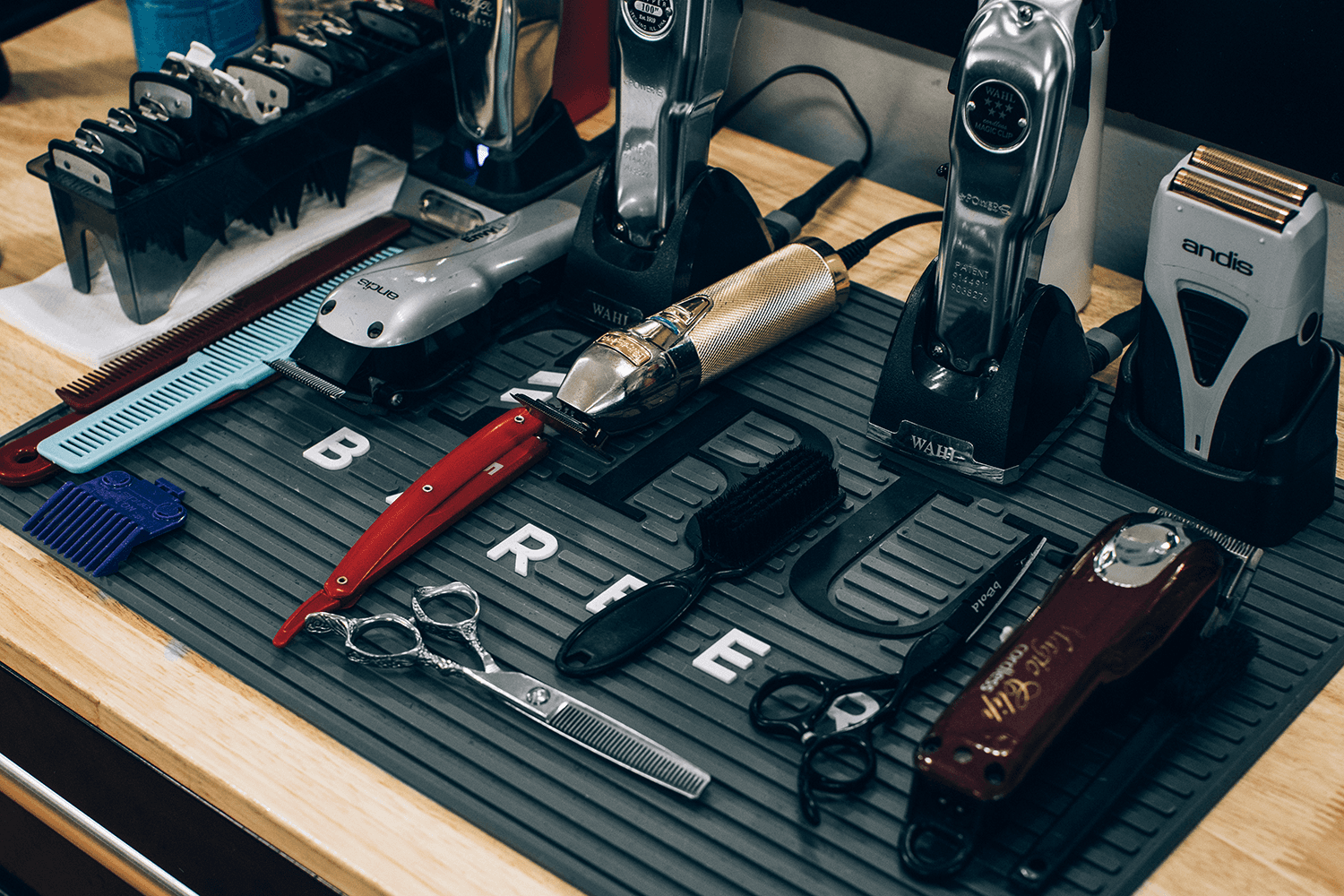 A Modern barber's tool set, various trimmers, scissors, combs on a non slip mat