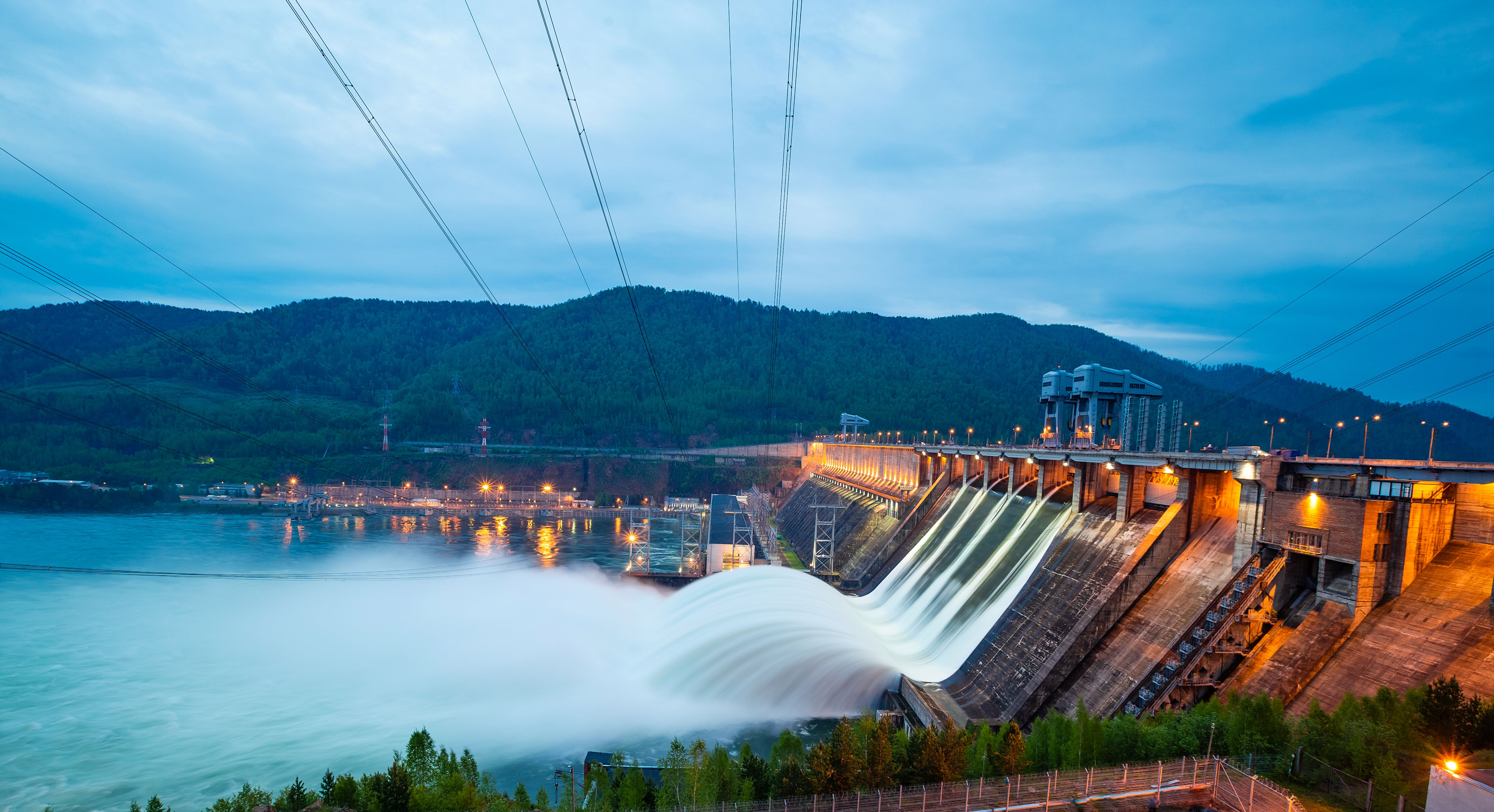 Hydroelectric dam with flowing water and turbine housing structures