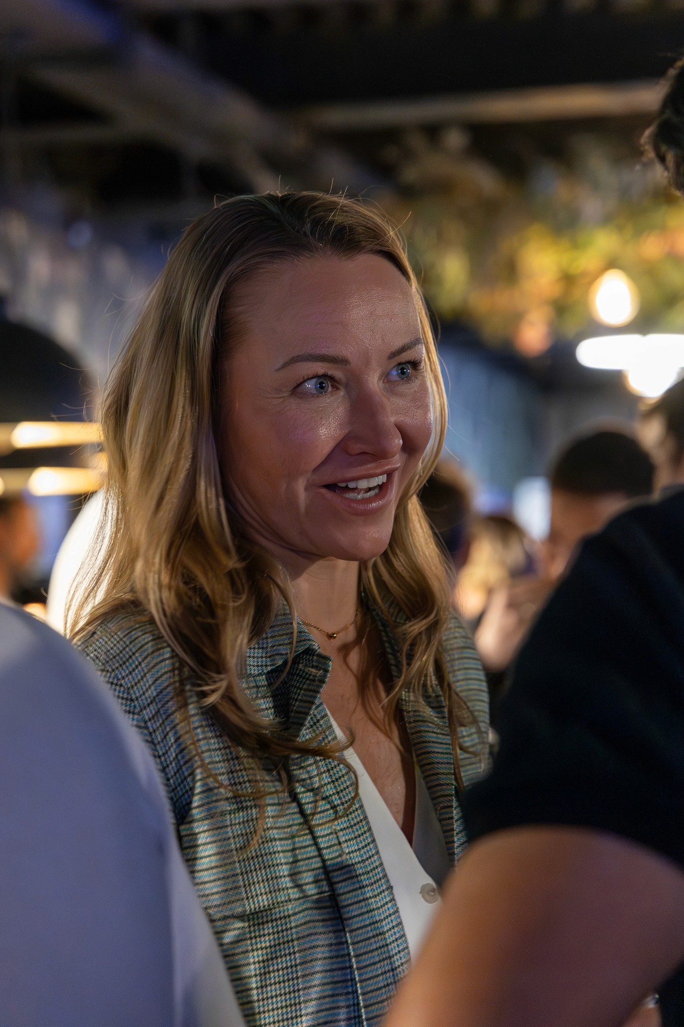 Woman networking during an evening reception at a Crypto Valley event.