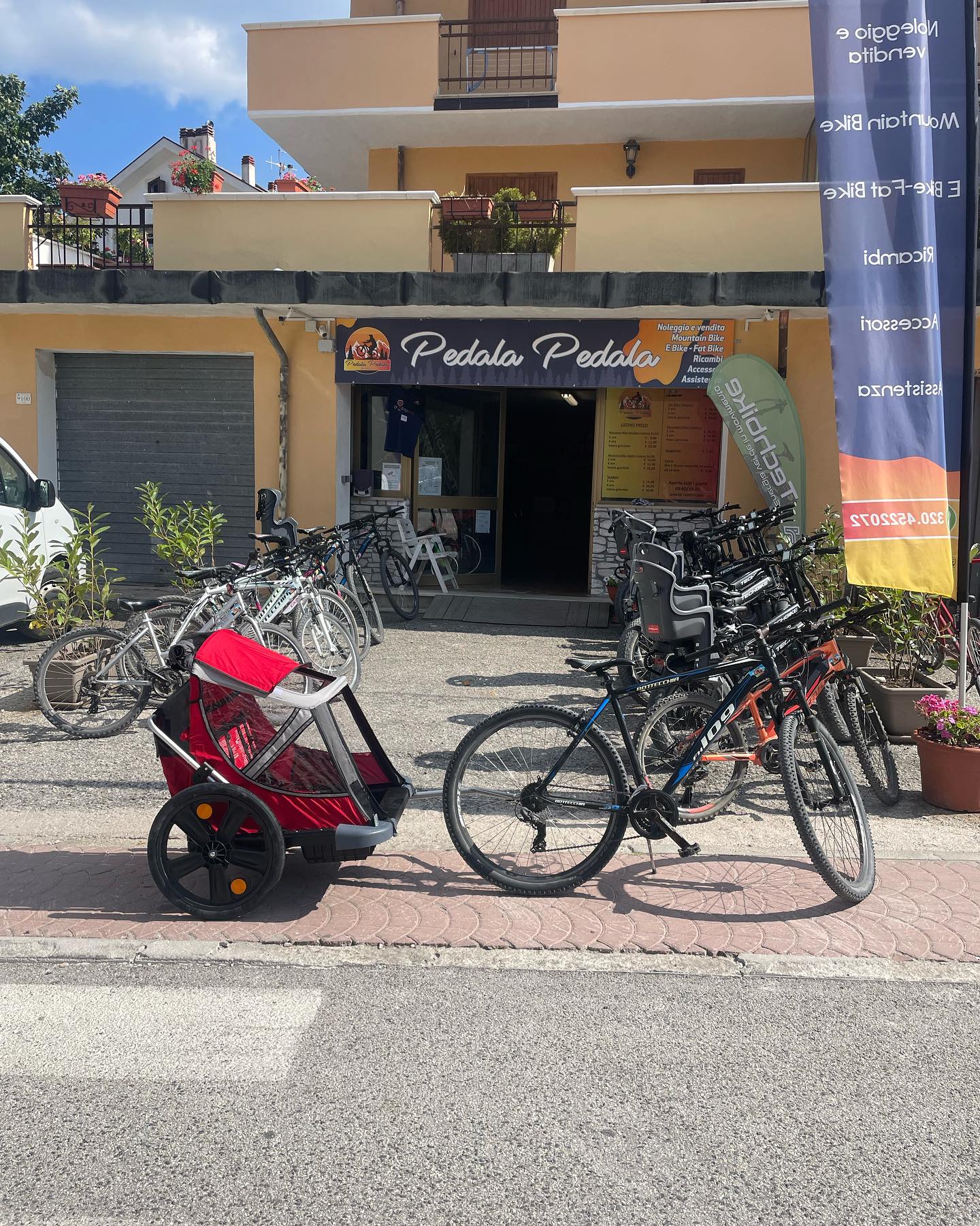bici con trasportino a traino per bambini e animali di fronte negozio pedala pedala ovindoli