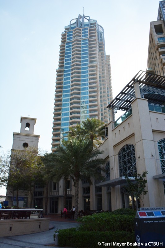 Modern residential apartment building showing high-end real estate and palm trees.