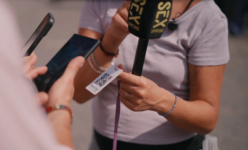 Woman with microphone and a SignTag with QR code in her hands.