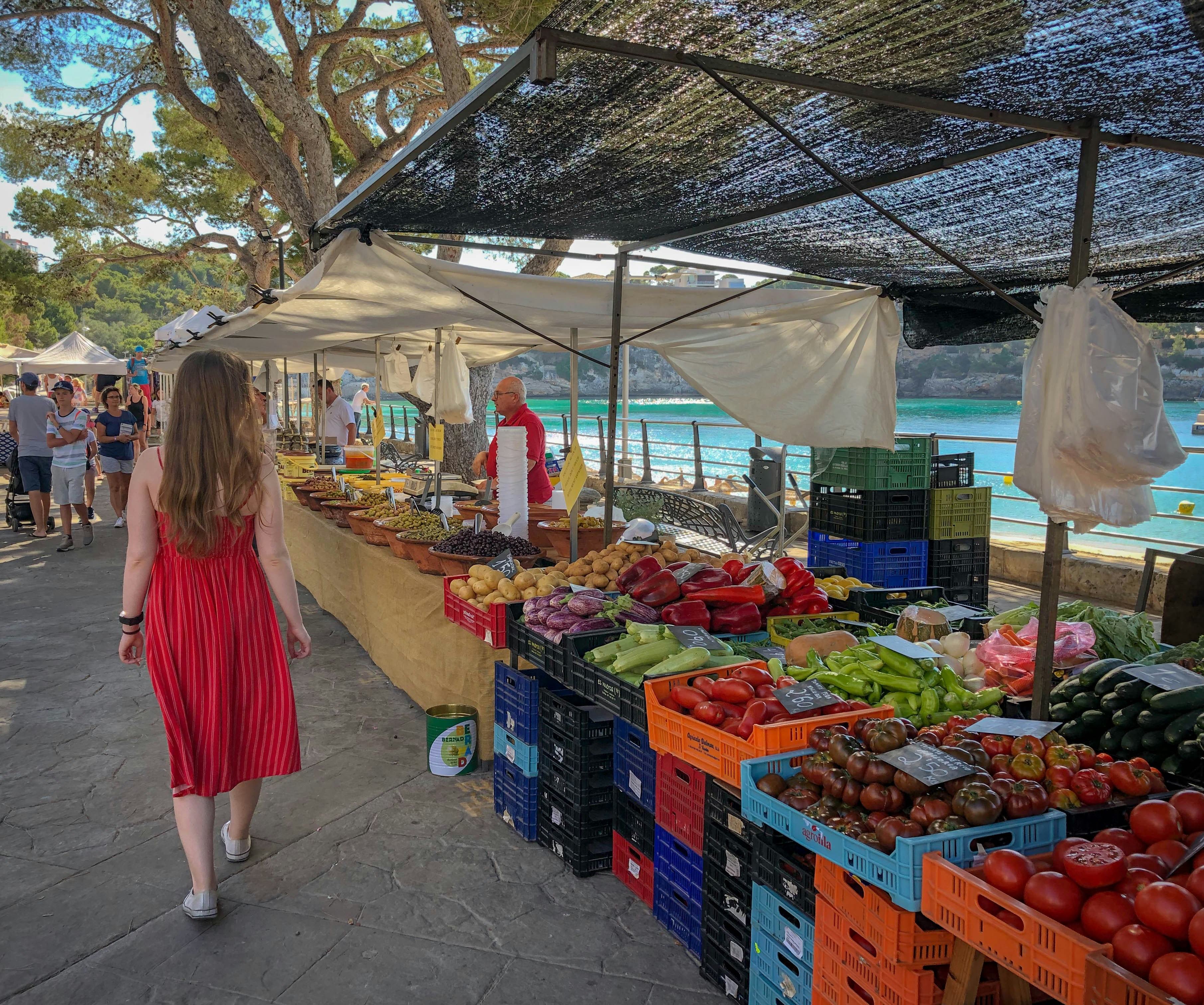 woman walking beside fruit and vegetable vendors