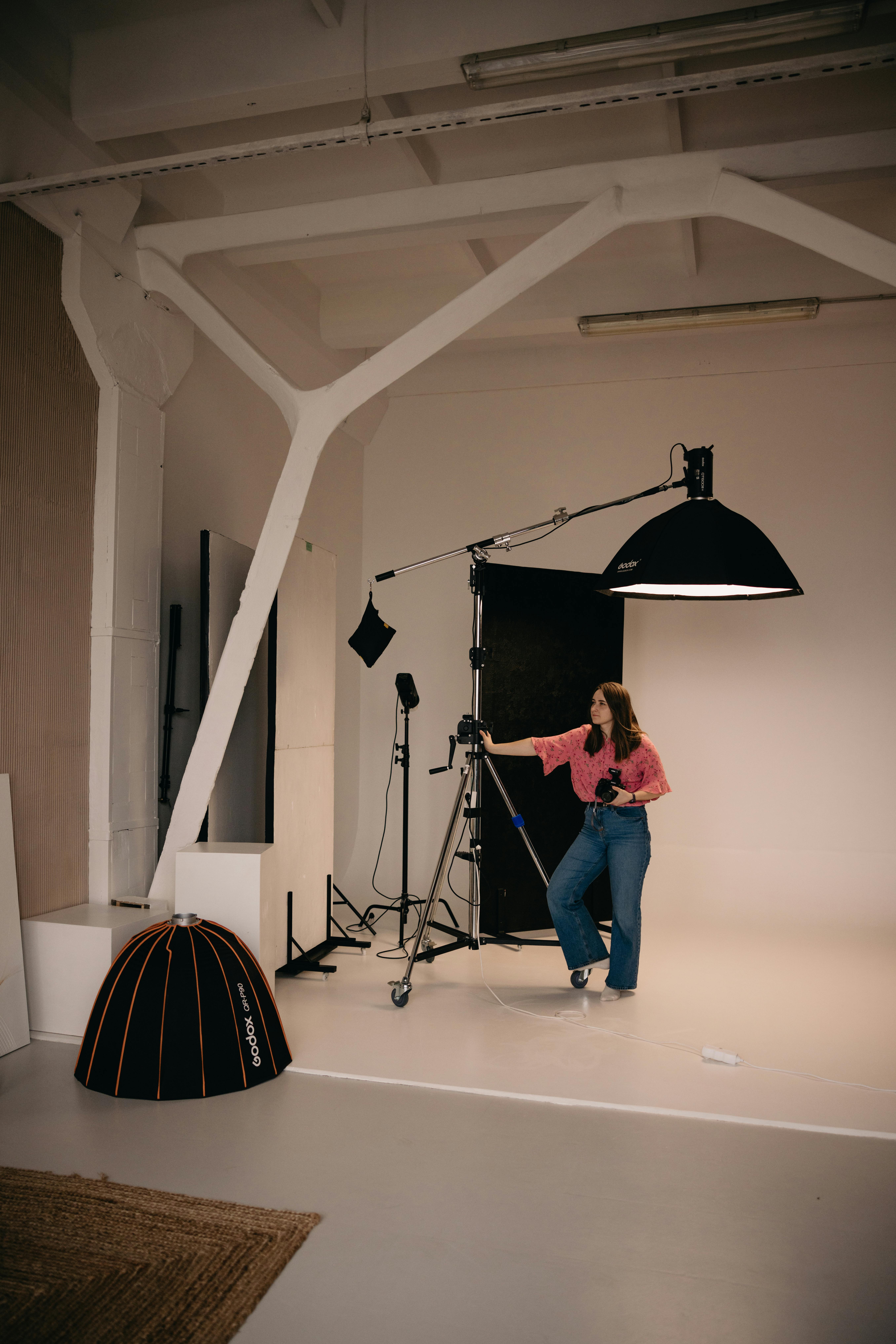Behind-the-scenes studio shoot with a camera, softbox, and photographer