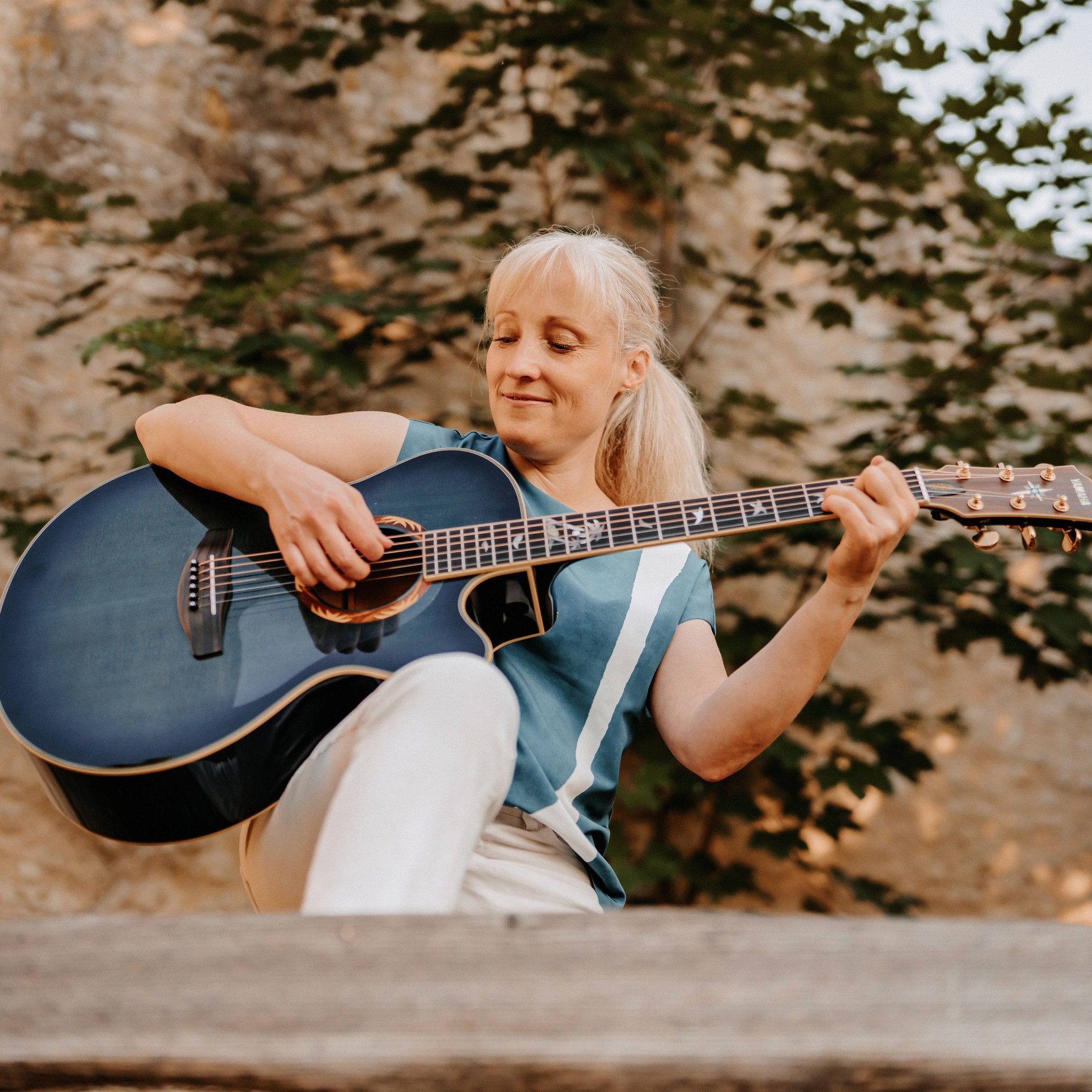 Sängerin Yvonne spielt voller Freude ihre Akustikgitarre – bringt emotionale Gänsehaut-Momente als Musikerin für eure Hochzeitsfeier.