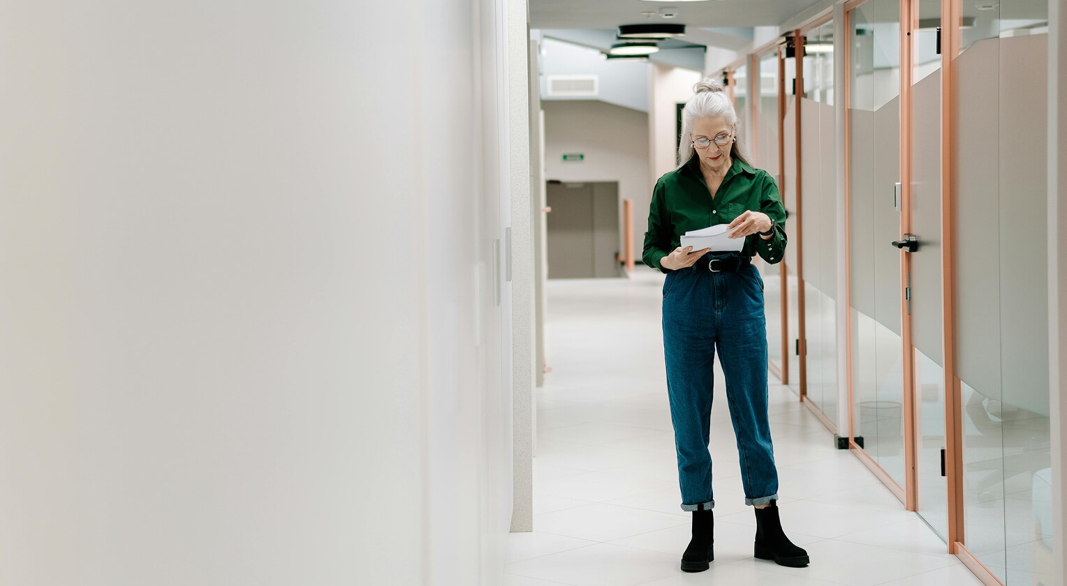 Older woman standing in the hallway of an office