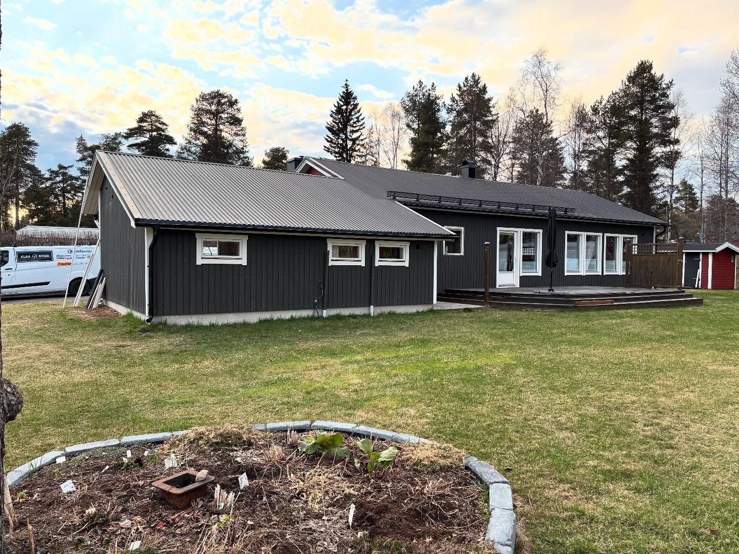 woman in blue jacket and blue denim jeans standing on brown wooden bridge