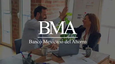 Fotografía de un asesor bancario y un cliente sonriendo mientras estrechan la mano frente a una computadora, representando el éxito en una gestión de consolidación de deuda.