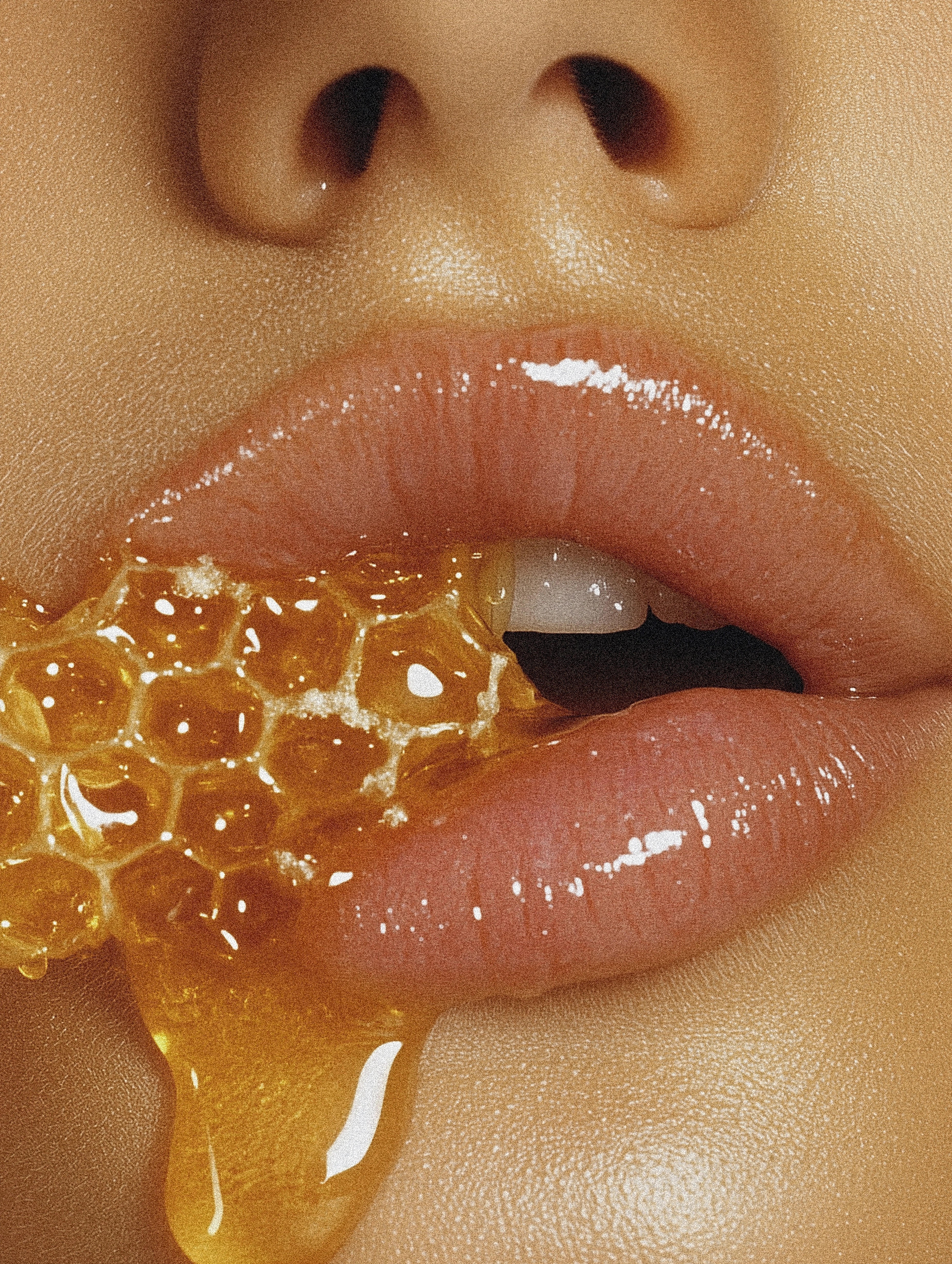 Glossy full lips with honey dripping over them, showcasing the natural texture of honey and smooth skin