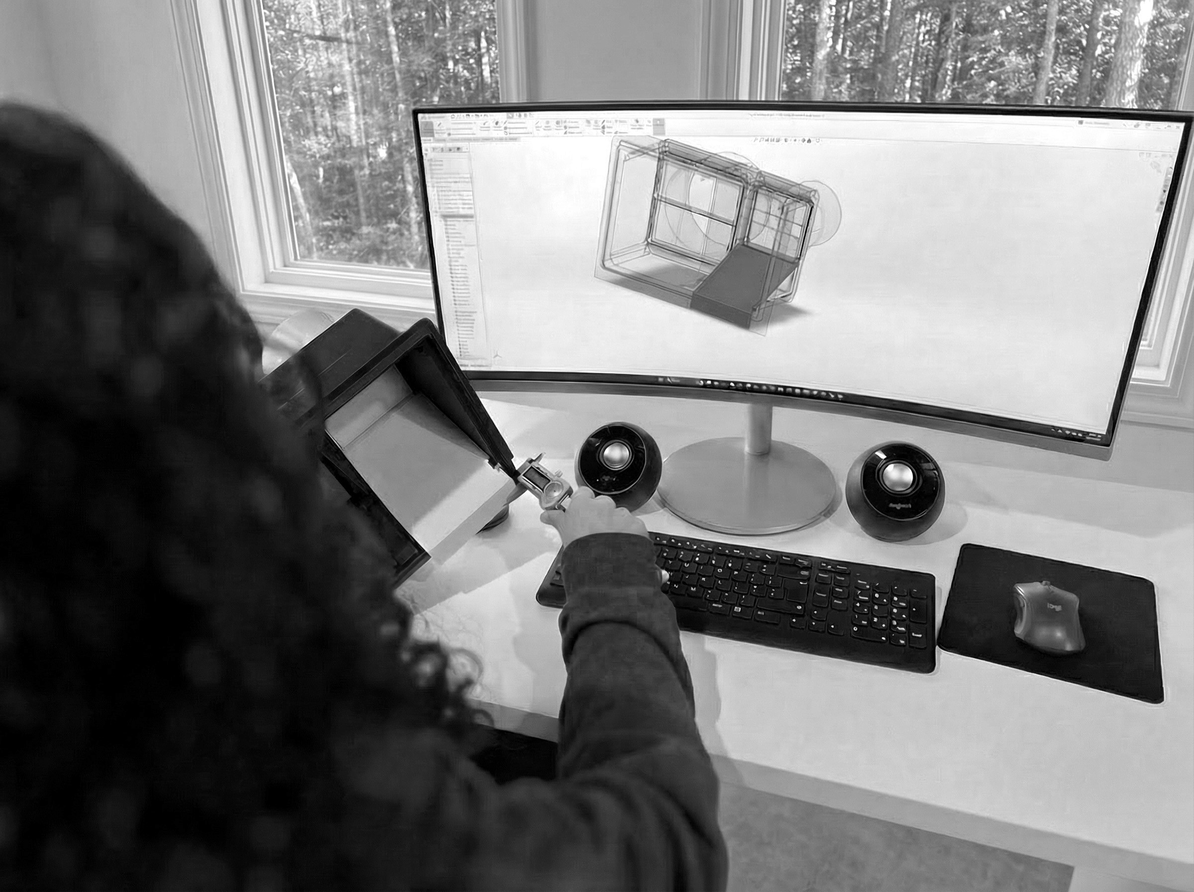 Black and white image of people working at a table with laptops, showing hands gesturing during discussion of digital content displayed on screens, with fabrica® logo in the corner.