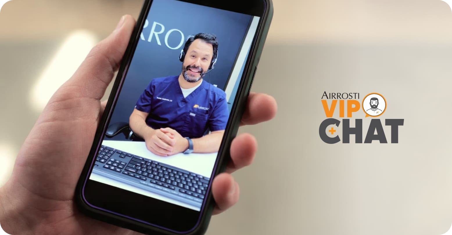 A person holding a smartphone with a telehealth call on it