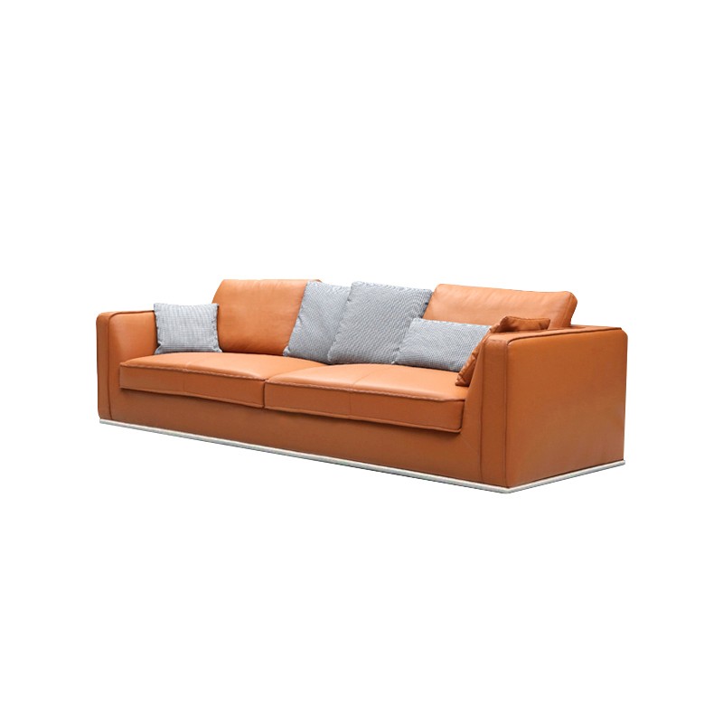 Contemporary burnt orange leather sofa, three-seater with plush cushions, gray patterned accent pillows, low-profile design and metallic base trim