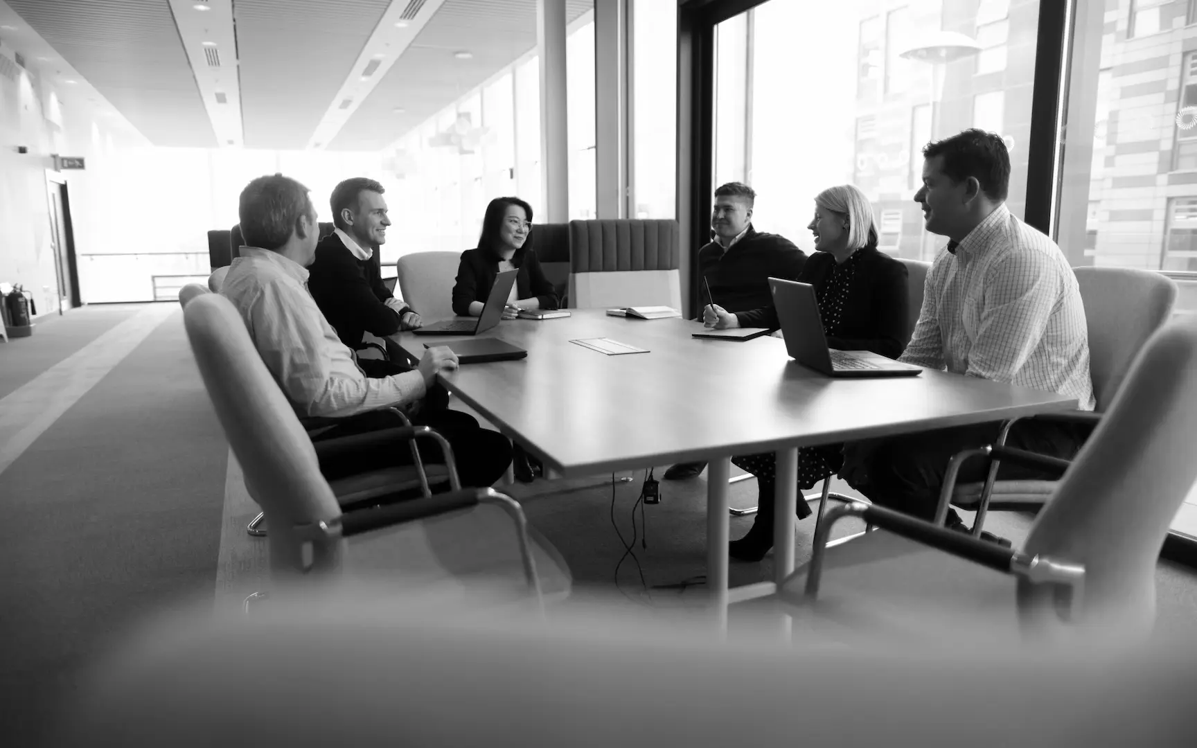 A black and white photo of and EverQuest Investment team meeting