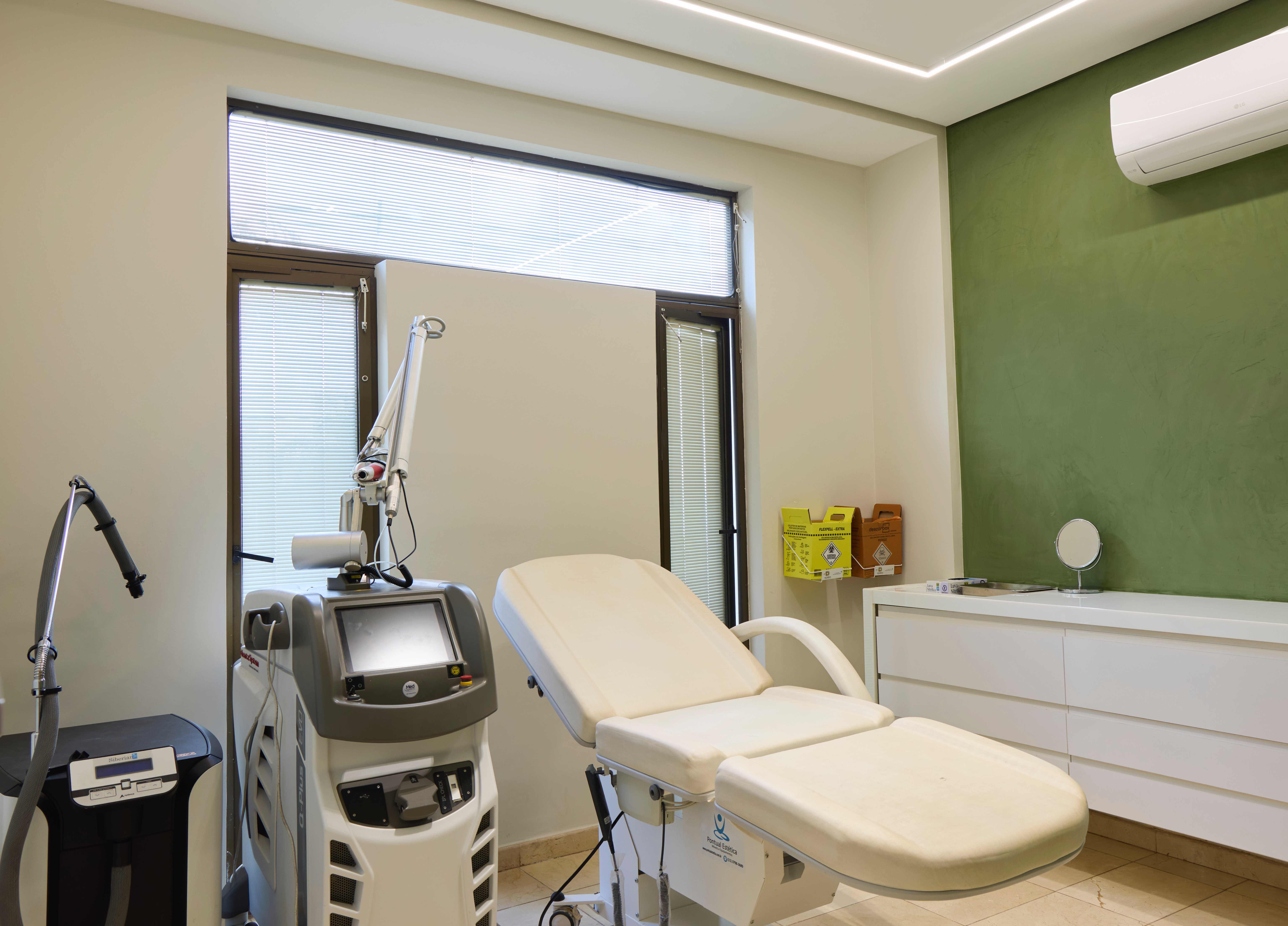 Sala de atendimento para remoção de tatuagem a laser, equipada com tecnologia médica avançada, maca clínica e ambiente moderno e confortável.