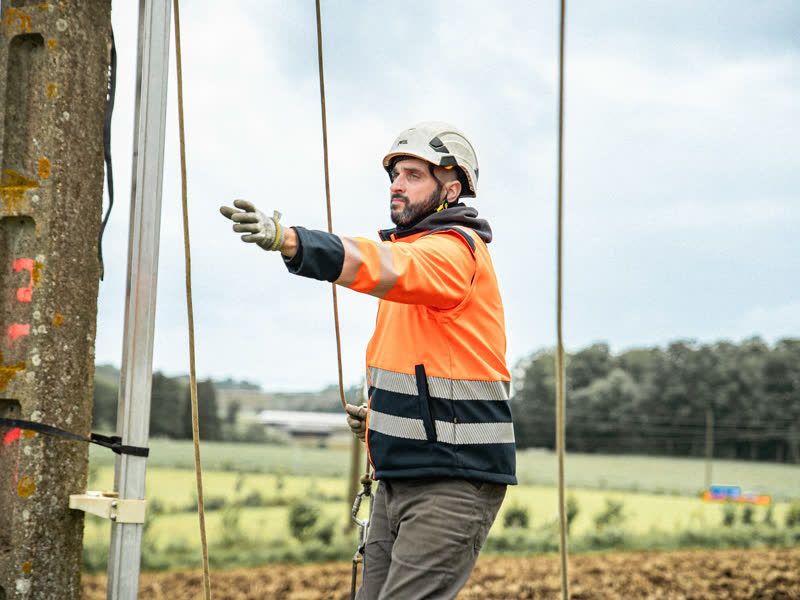 Monteur ajustant un support sur un poteau
