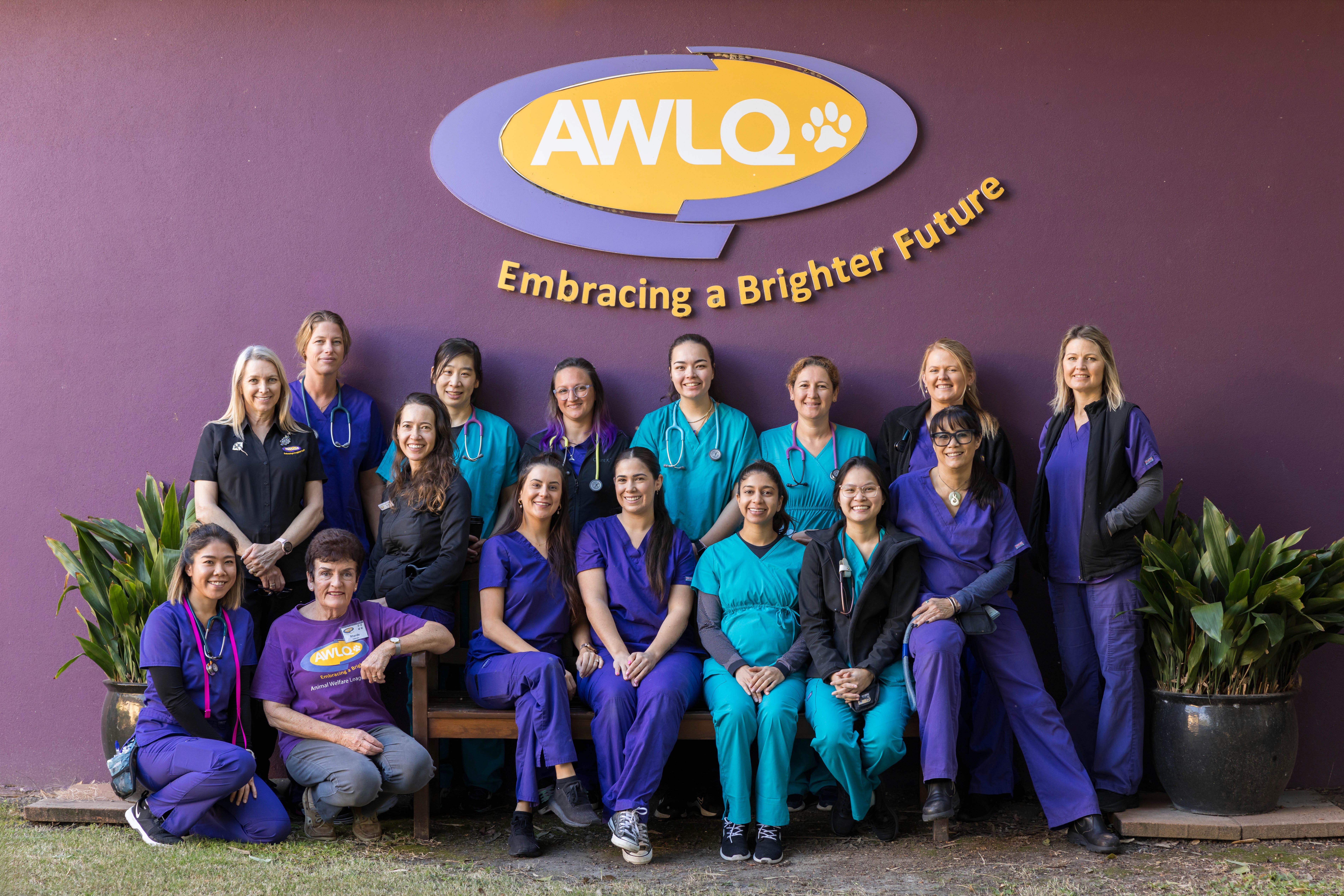 Group portrait of vets and vet nurses in front of purple wall