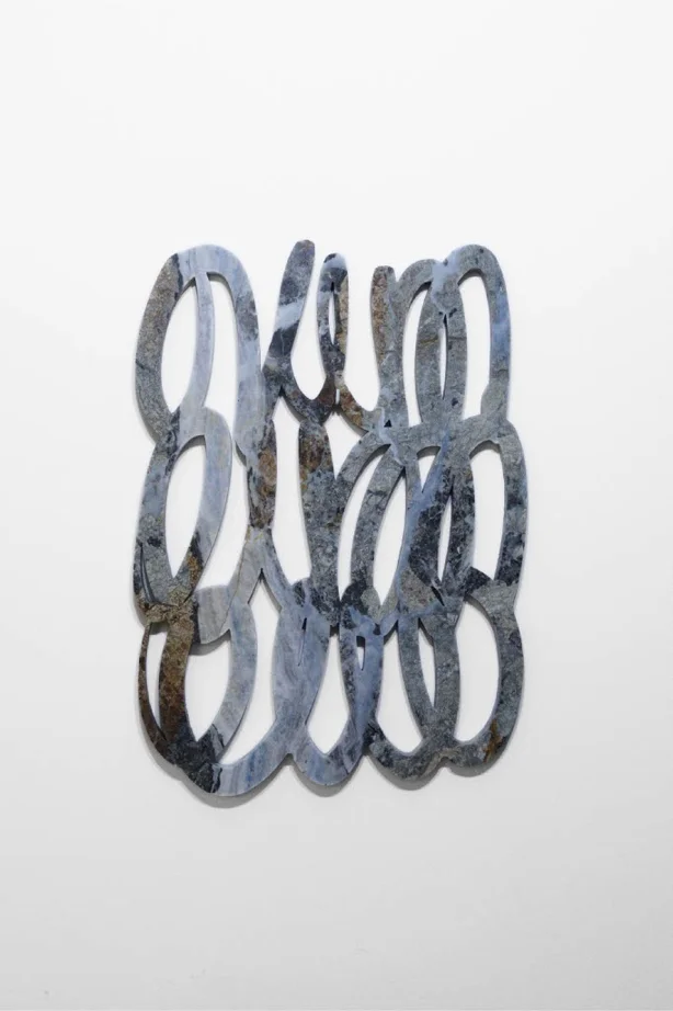 Scultura astratta in pietra grigia con forme intrecciate, opera contemporanea iStone Arte che esplora geometrie fluide e texture naturali per valorizzare brand artistici