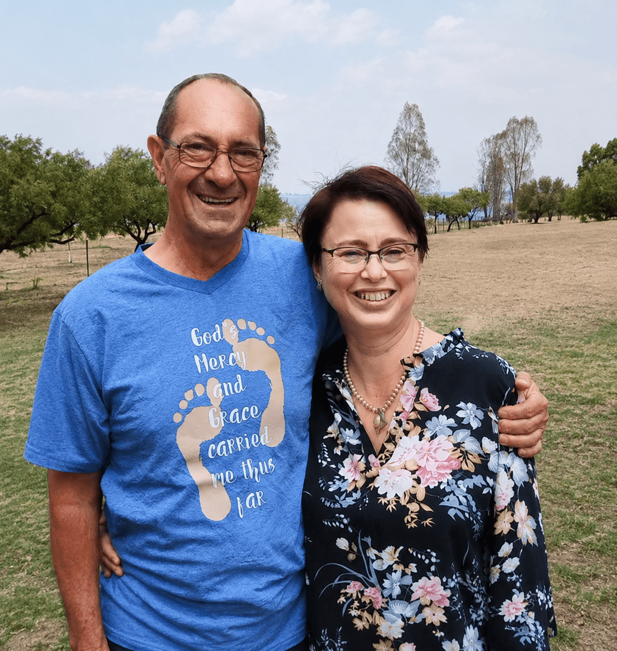 a man in a blue shirt smiling at the camera