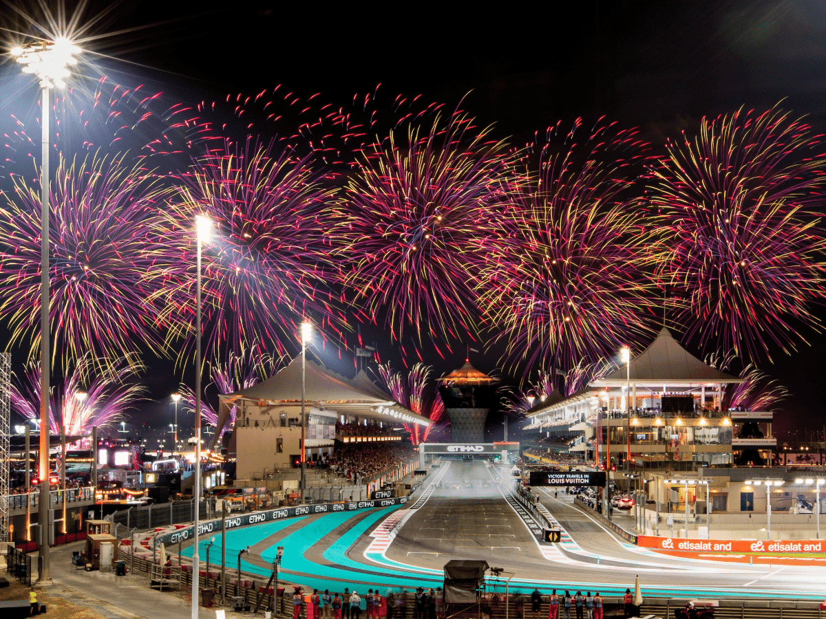 Fireworks above the Yas Marina straight and grandstands at night.