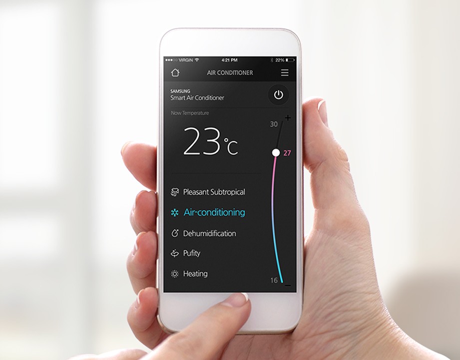 사용자가 스마트폰으로 실내 온도를 조절하는 스마트홈 제어 장면