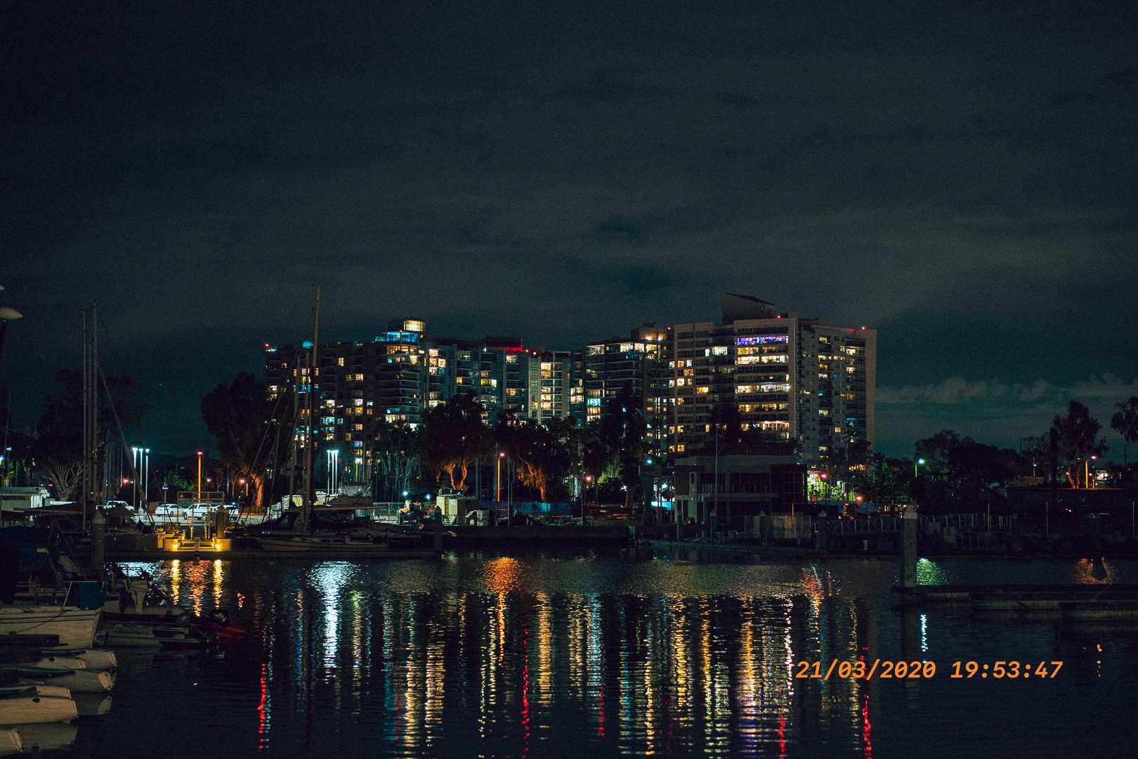 Marina nocturne, reflets colorés sur l’eau calme
