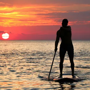 Stand-up paddleboarding at Tarifa beach during vibrant sunset – Extra Activities Tarifa