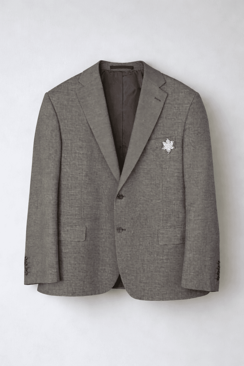 Light grey blazer with decorative pin on lapel