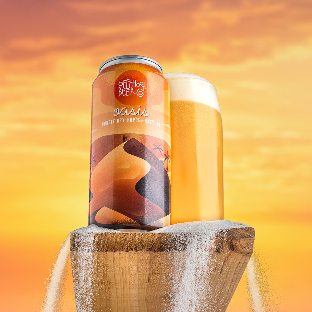 Desert sunset beer can and pint glass on rock