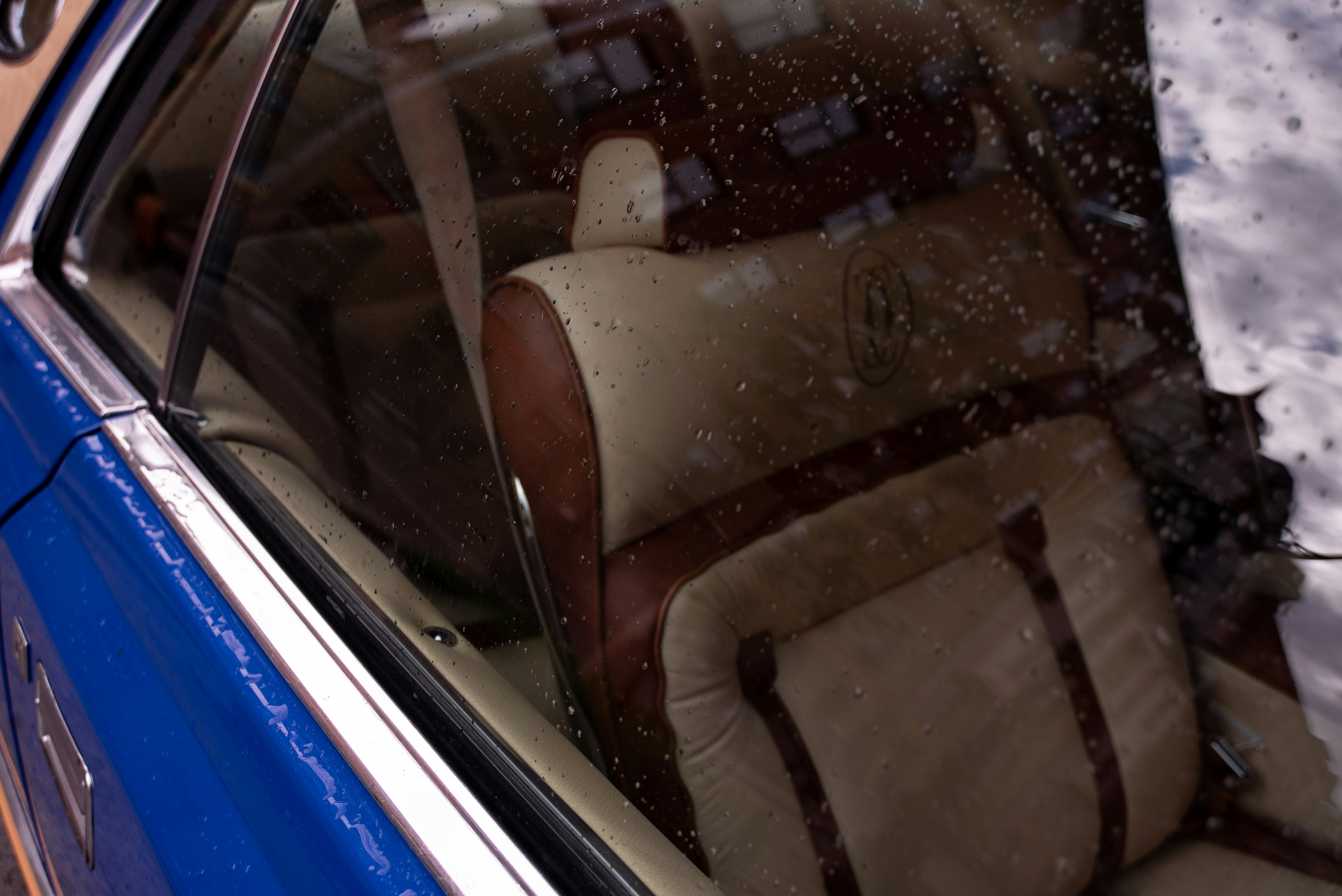 Here is a caption for the image: **inside a classic car with a cozy seat.**