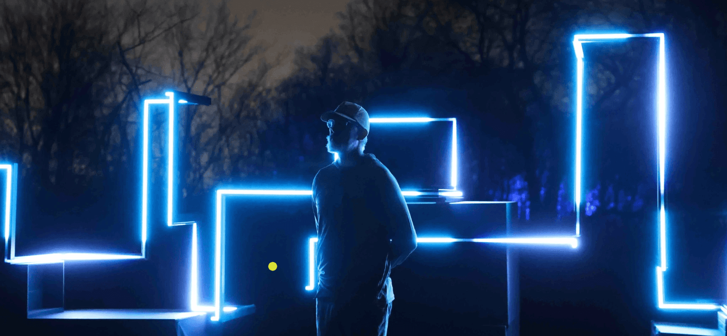 A theater stage set up with performers, viewed from the audience seats with red carpeting.