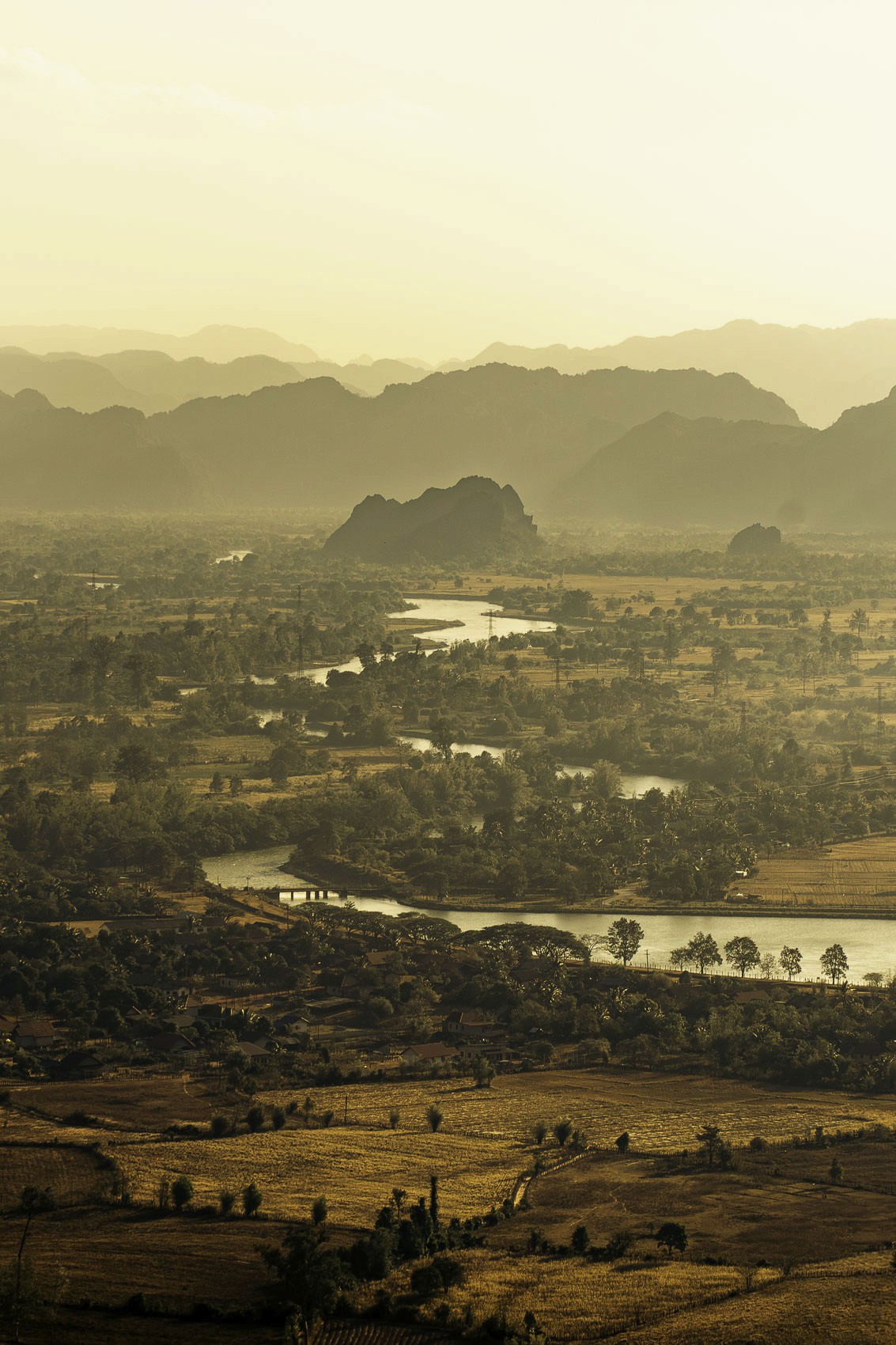 Paysage en hauteur au Laos au coucher du soleil avec une rivière traversant les champs, photographie de voyage par Robin Masson
