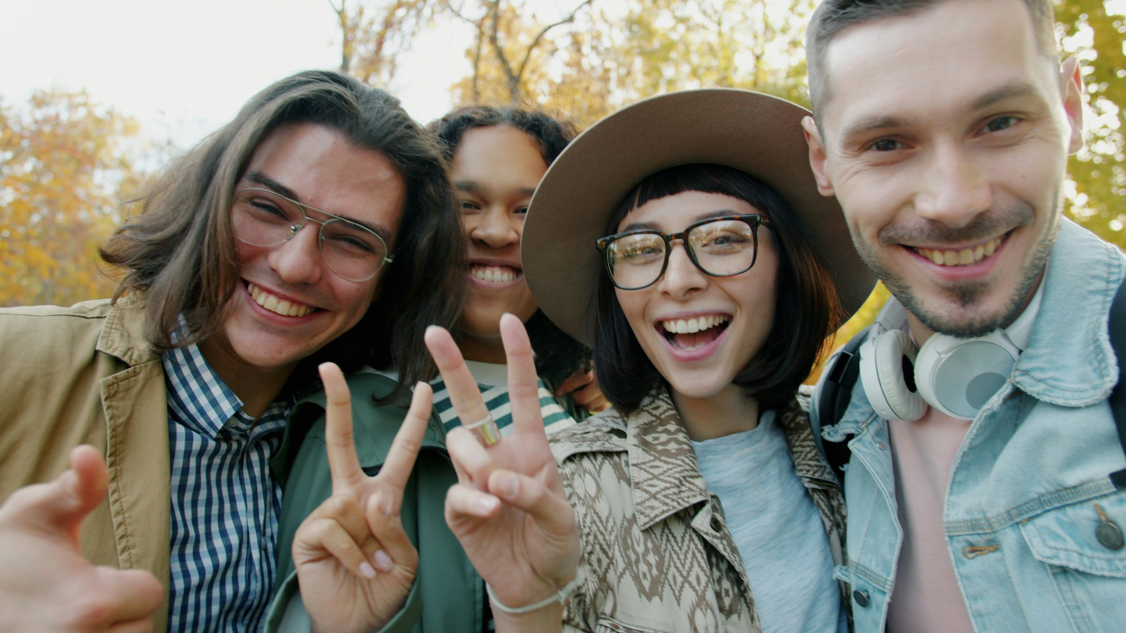 Four friends taking a selfie outdoors in autumn
