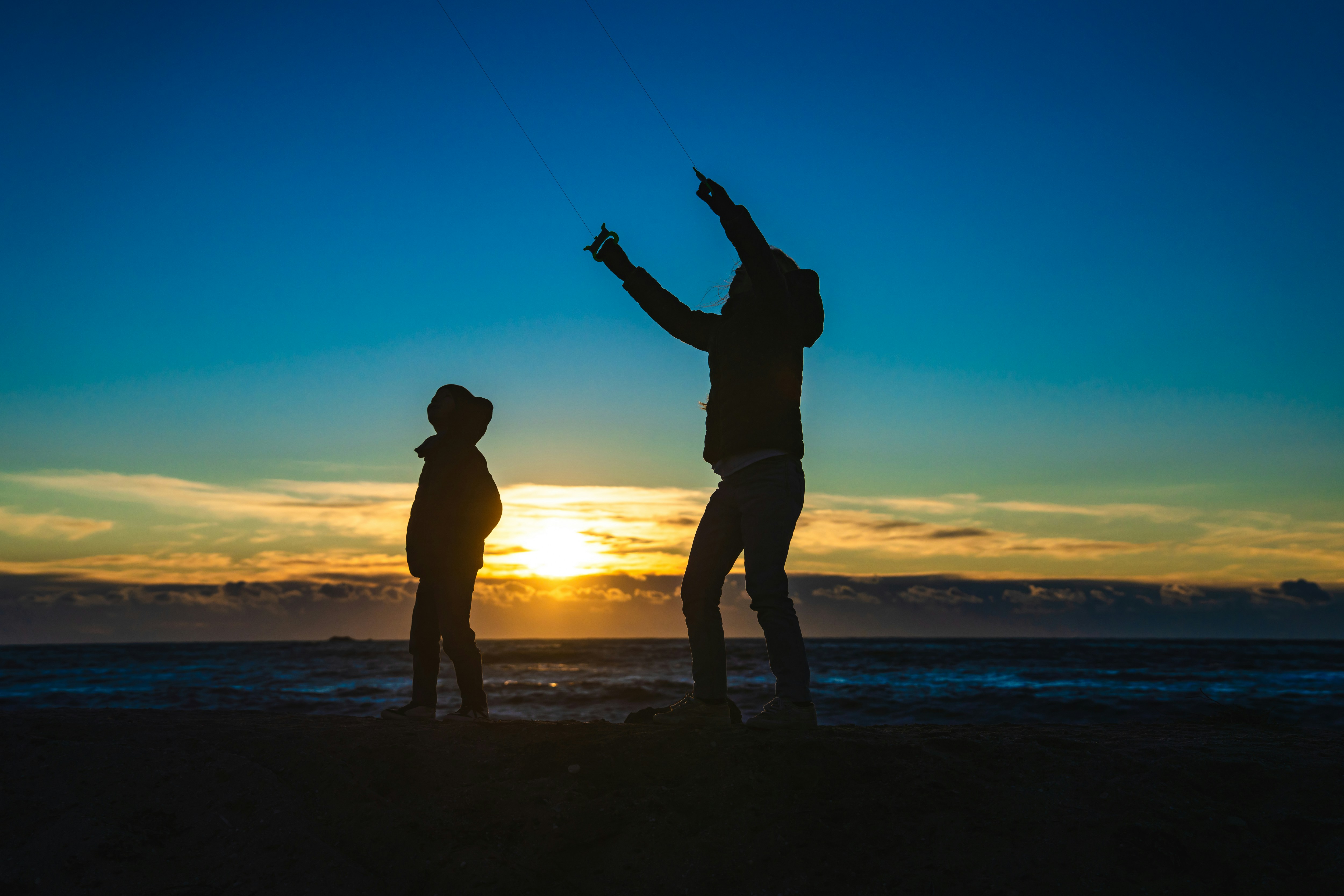 A couple of people standing on top of a beach