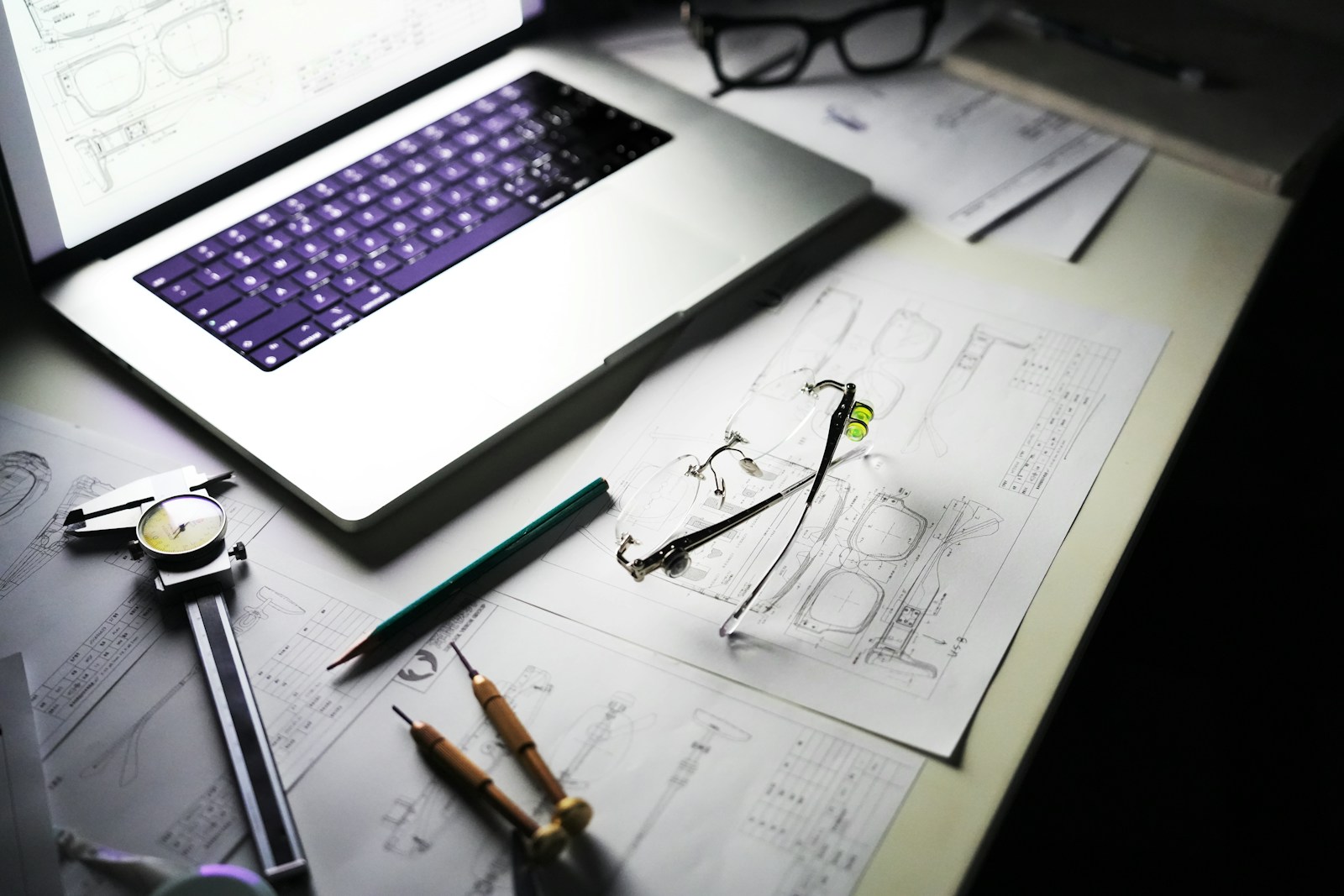 Eyewear design sketches on a desk with an engineer's notes