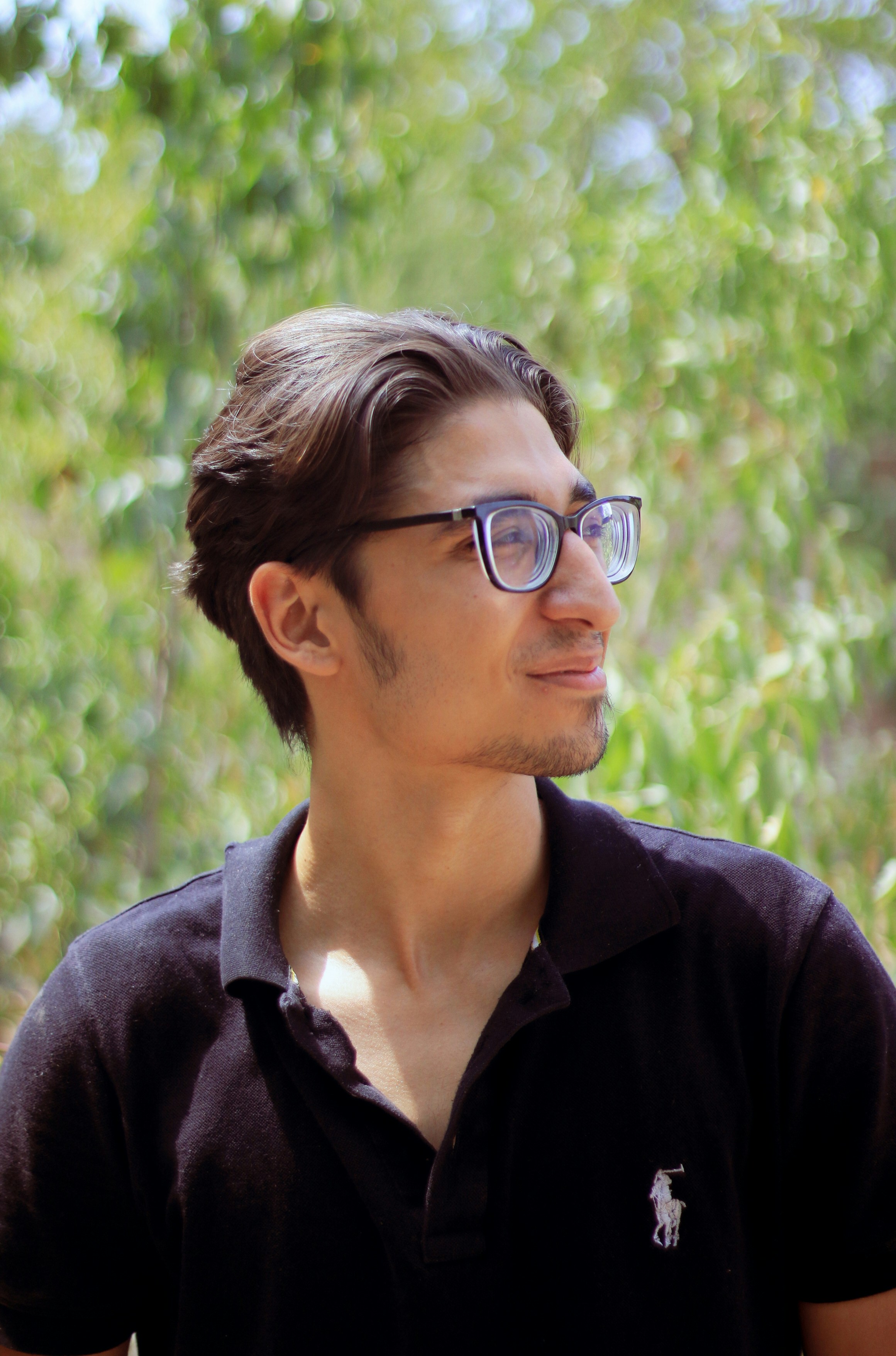 a man wearing glasses and a polo shirt