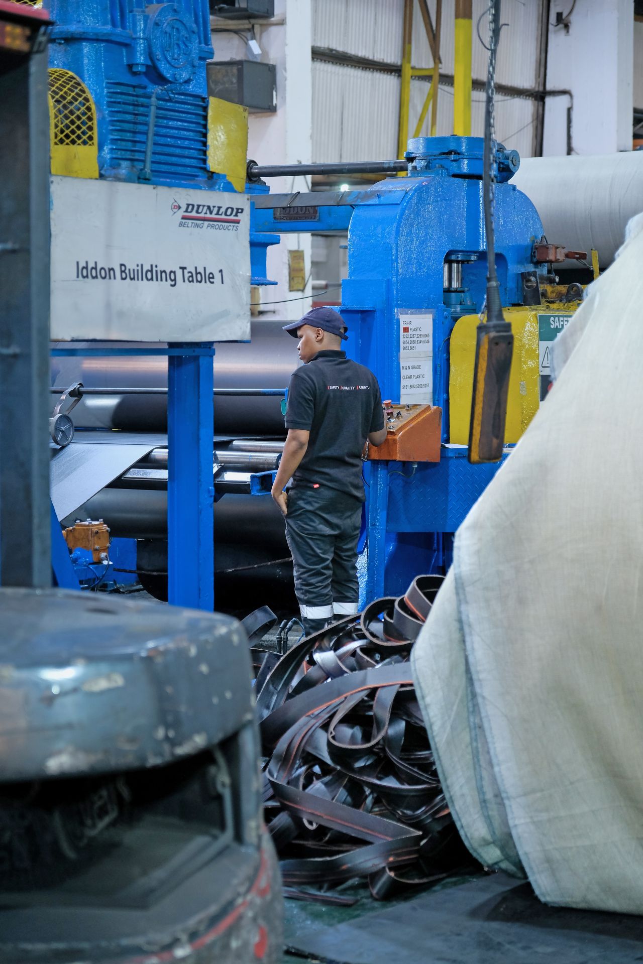 Close-up of a dark green leaf showing its textured surface and central vein against a muted background.