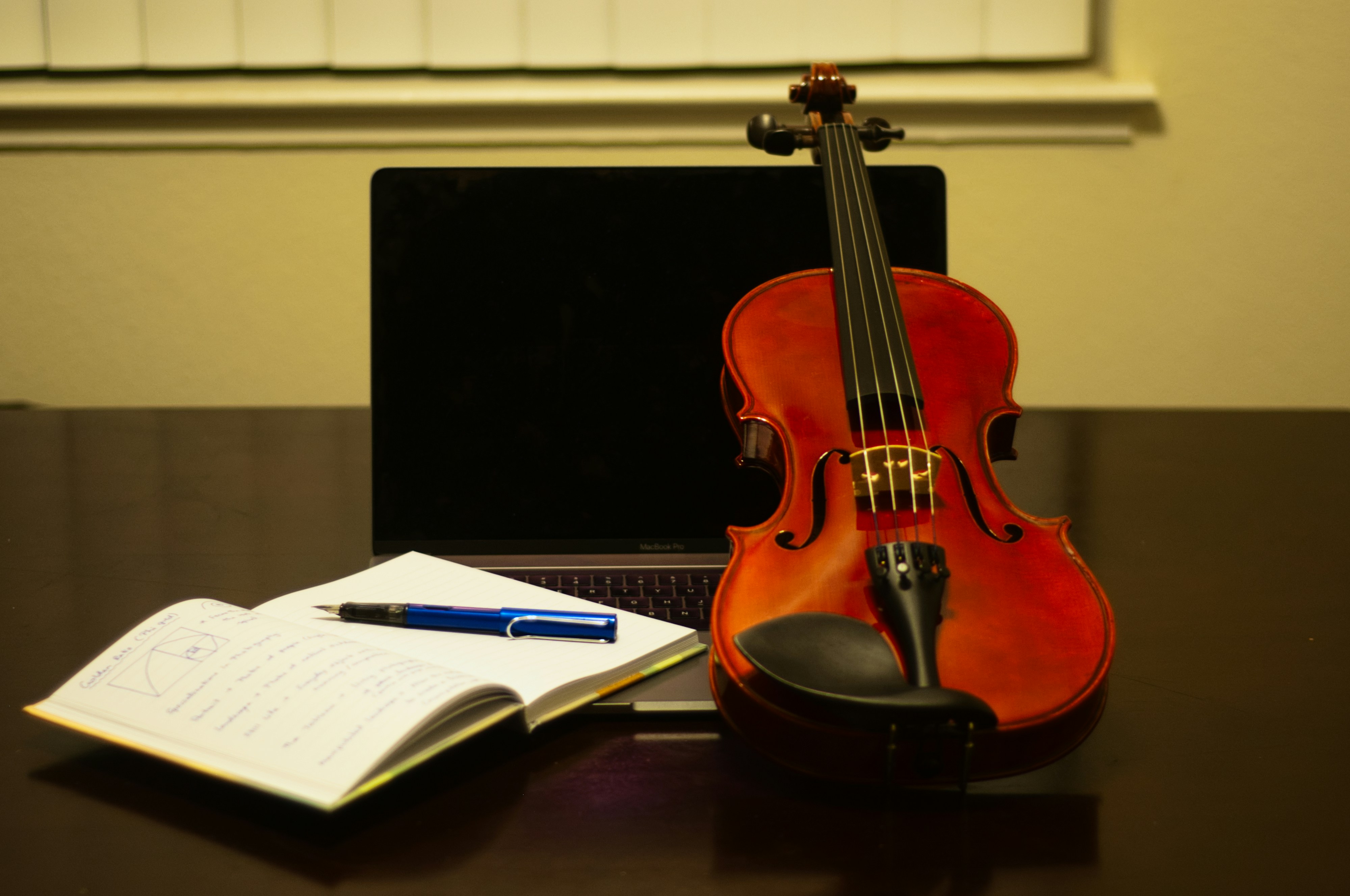 textbook with pen and guitar - How To Write A Song