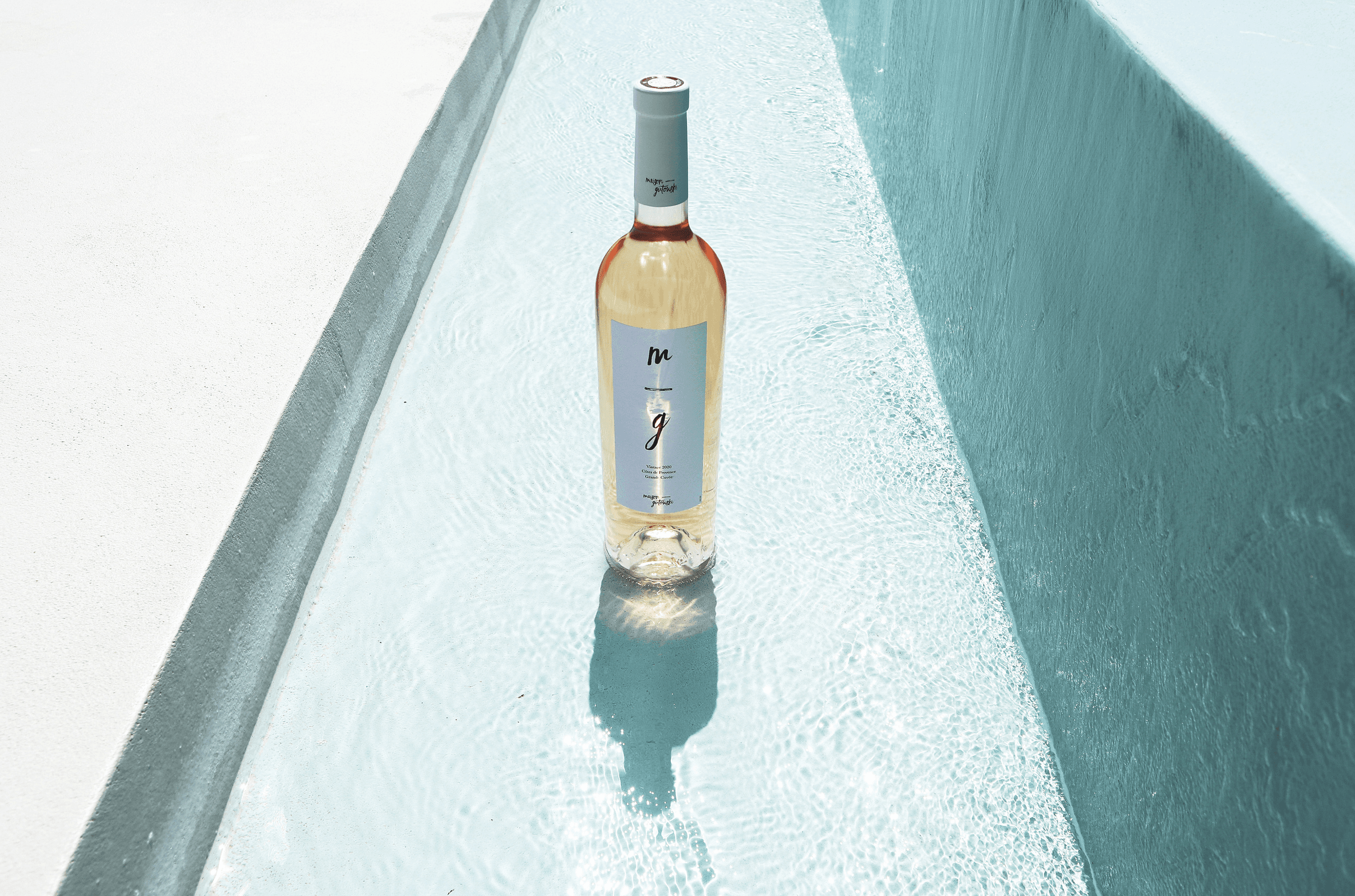 une bouteille de vin MG dans de l'eau turquoise
