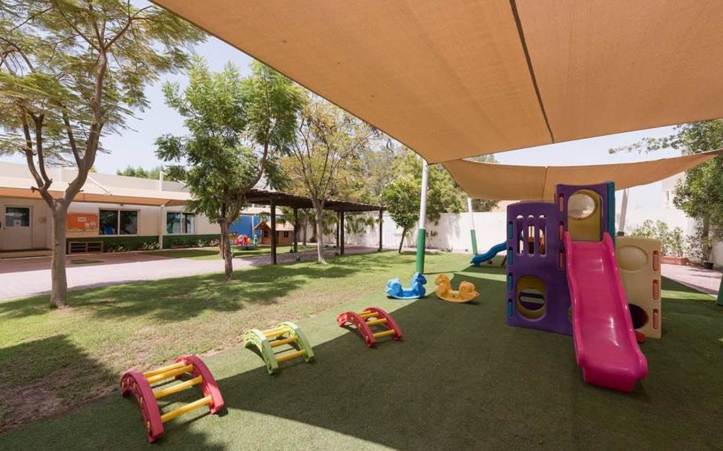 A playground in Al Seef featuring a slide, swings, and various toys for children to enjoy.