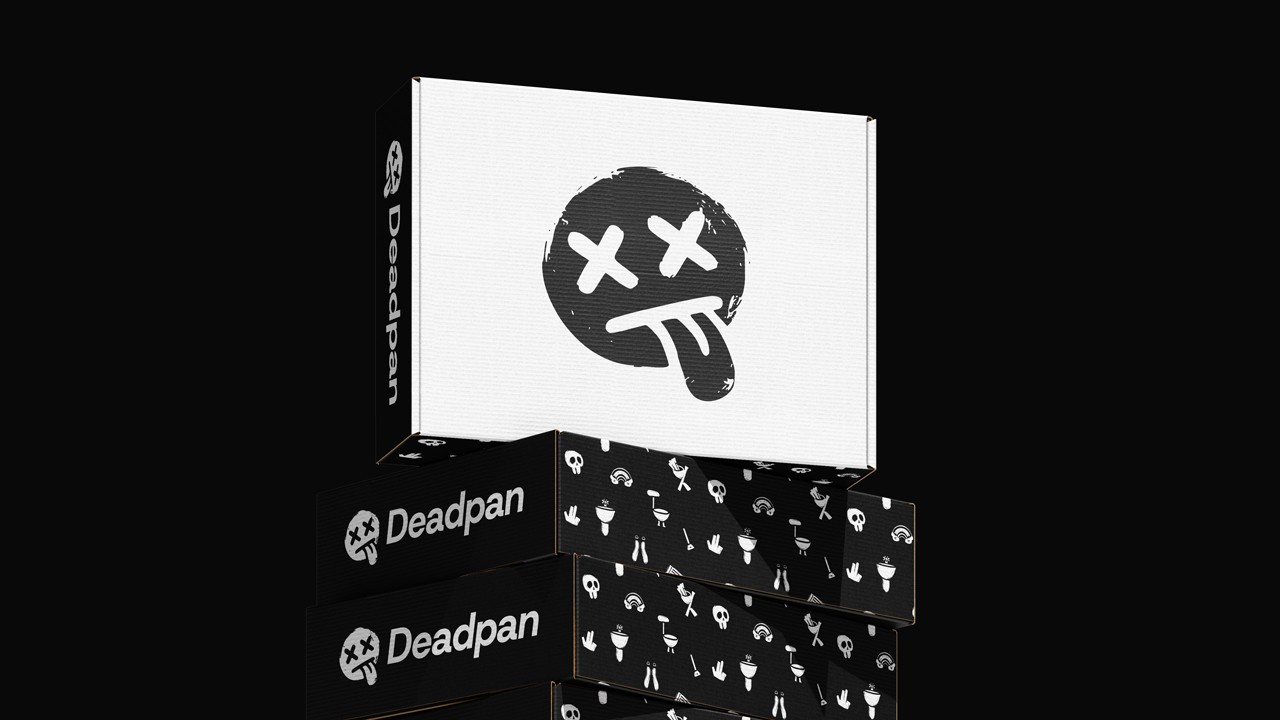 Stack of black-and-white Deadpan shipping boxes: a large white box on top with a distressed black smiley face logo (X eyes, tongue out), and beneath it several black boxes printed with small white icon patterns and “Deadpan” branding on the sides, all against a pitch-black background.