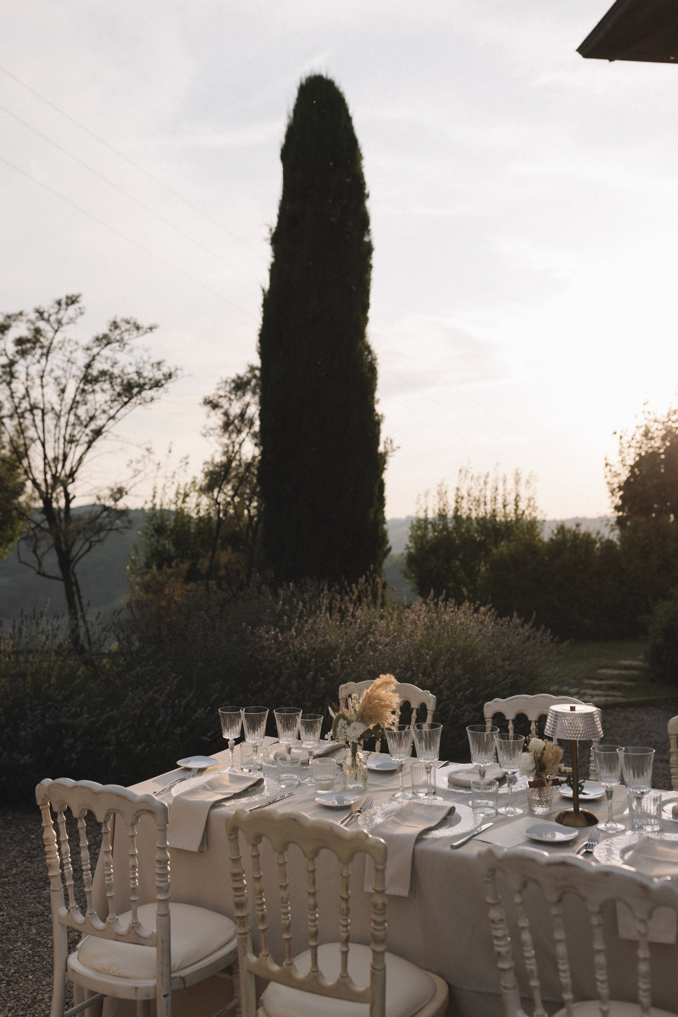 Tavolo rotondo per il ricevimento nel Parco di Montebello, con cipressi e luce dorata del tramonto, matrimonio a Parma