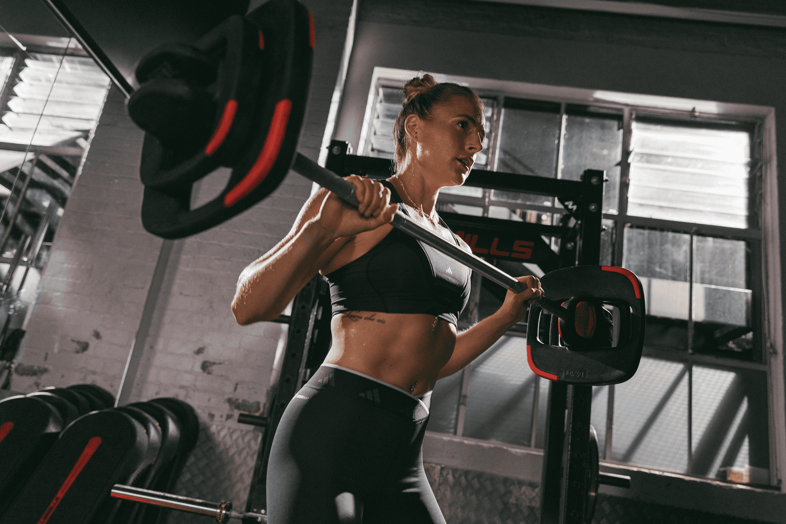 Ein weibliches Mitglied von XTRAFIT nimmt an einem der über 20 Kursformate teil, um den Rücken zu stärken und mit der XTRAFIT Community gemeinsam zu trainieren.