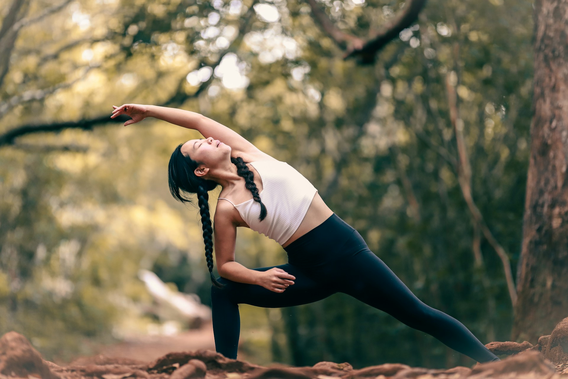 Woman in a gentle yoga pose amidst nature