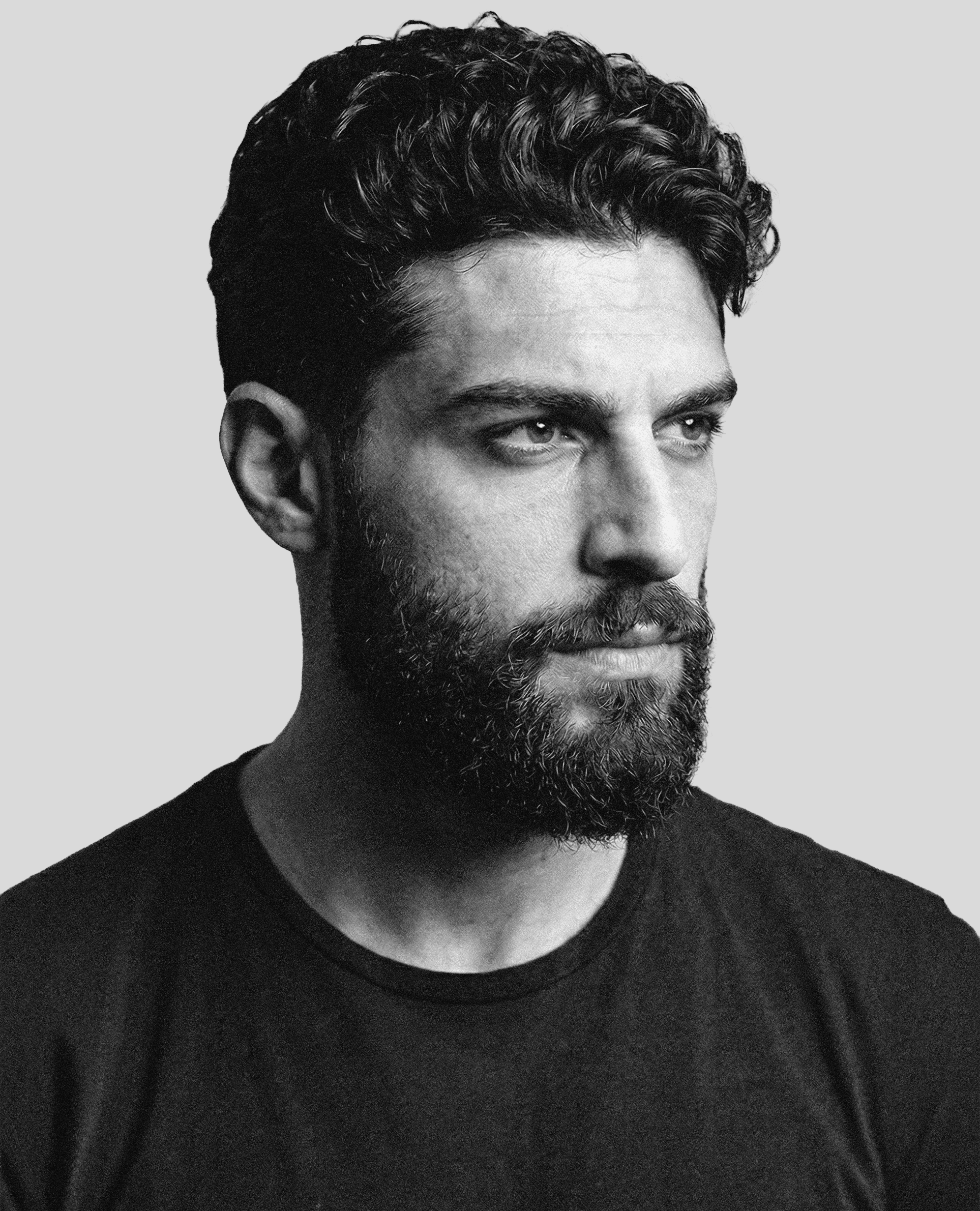 Portrait of a woman with straight long hair, in a dark t-shirt, set against a neutral backdrop.