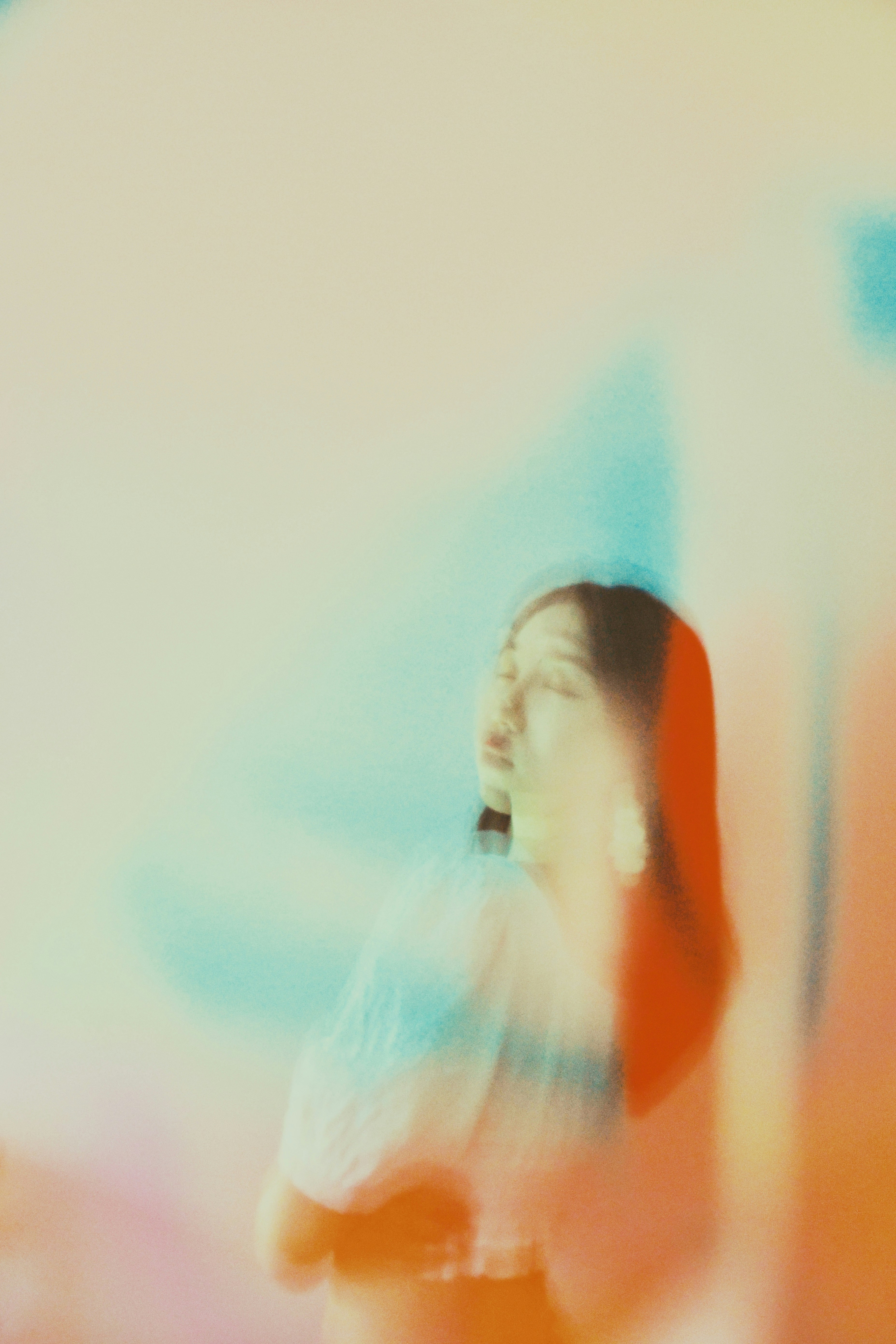 a blurry photo of a woman standing in front of a wall