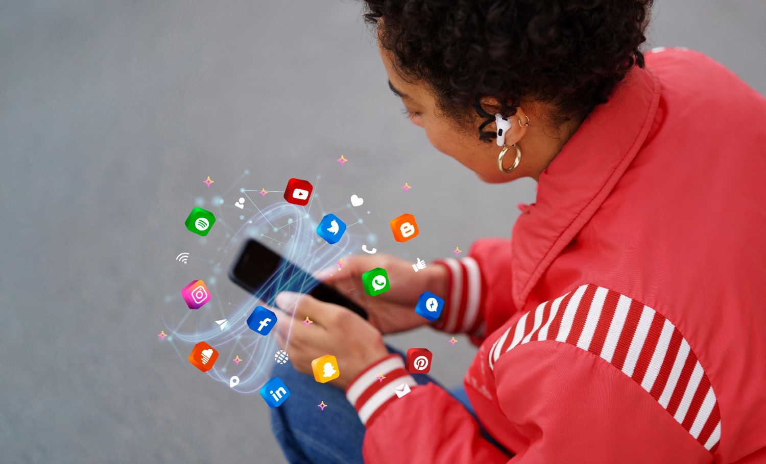 2. A woman on the ground, interacting with her phone, surrounded by floating social media icons.